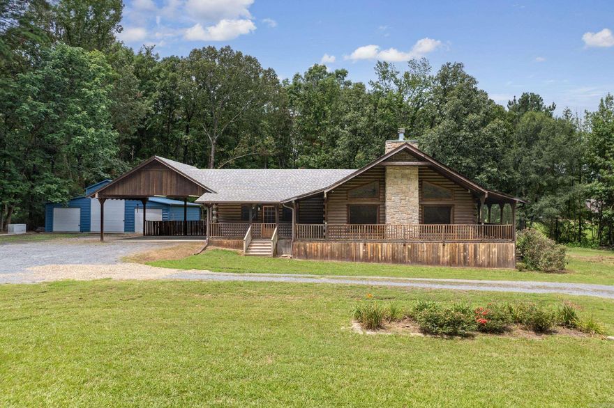 Everyone is going to love this massive custom log cabin that offers amenities and designer touches around every corner. Completed in 2011, this Satterwhite log home was thoughtfully modified to accommodate every member of the family. Each bedroom features its own en-suite bath and large walk-in closet, and the hallways and doors are wide enough for a walker or wheelchair.  What may be the longest residential hallway in the county includes a powder bath for guests, a coat closet, and track lighting that will highlight your extensive art collection or photo gallery...and leads to an enormous master suite with TWO walk-in closets. An eat-in kitchen is filled with custom cabinetry and a Swedish AGA Legacy range that will make even a beginner chef feel like a pro; the huge laundry room and walk-in pantry are adjacent. Artist-inspired colors throughout will bring your furnishings to life and awaken your interior design skills. The wrap-around porch is screened on the back and side of the home. A two-acre lot showcases flower beds filled with roses and day lilies, a fence for your pets, an expansive three-bay metal garage with fluorescent lighting, and a whole-home Generac generator.