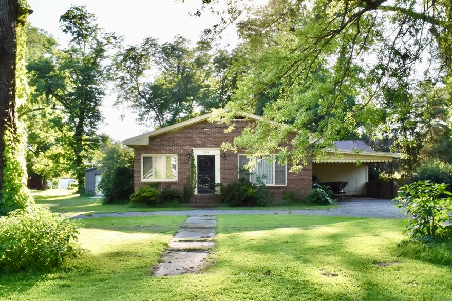 This mid-20th century ranch style home offers 2,400 square feet of comfortable living space. Embrace its vintage finishes or modernize to suit your taste! The bright, open den features a fireplace and leads into a quaint formal dining room. A cozy office space is tucked away next to the front door. The kitchen has room for a breakfast table and blends seamlessly into the family room that has large windows looking out onto a the back deck. The backyard boasts a 24-foot by 32-foot shop, offering ample space for hobbies or storage. Adjacent to a property also for sale, this home provides an opportunity for expansion or investment. Located a short walk from the local library and situated in one of the safest small communities in eastern Arkansas, this home combines convenience, charm, and potential. Don't miss the chance to own this delightful property and create your perfect home. Call today for a private showing! Agents, please see remarks.
