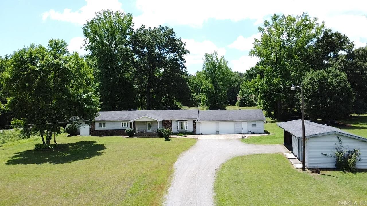 A little piece of country in the Mountain foothills. This beautiful custom built, 3 bedroom 2 bath home is nestled just as you begin the climb up into the Ozark Mountains. Home sits on 7 acres m/l with a park-like back yard where you can sit inside the screened porch, open deck or on a swing watching wildlife, while listening to a babbling stream with a footbridge crossing into a field containing a rustic barn. Home has a 2 car oversized garage, additional workshop, equipment shed, and storm shelter. The inside has an inviting fireplace, custom cabinetry, built in closet shelving, large walk in primary closet, alarm system and tons of storage thorough-out. New HVAC in 2024. New flooring with luxury vinyl & tile, subflooring and vapor barrier throughout in 2021. New roof 2022.