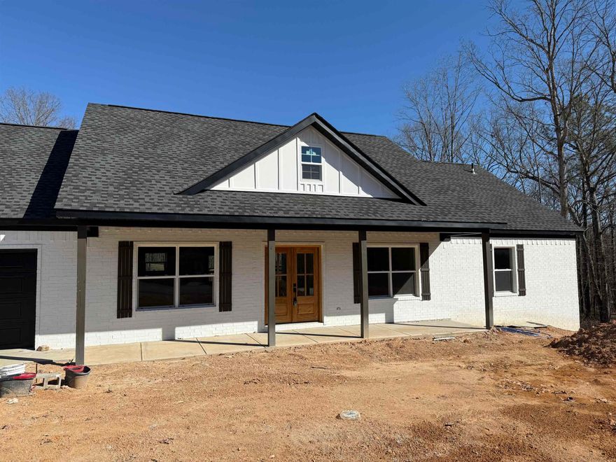 This nearly finished new construction home features four spacious bedrooms and two bathrooms, ideal for family living. It boasts large walk-in closets and a luxurious soaker tub in the master bath. The impressive granite-tiled walk-in shower adds a touch of elegance. The open-concept layout enhances flow between the living and dining areas, while a cozy granite fireplace provides warmth and style. Enjoy outdoor living on the covered back deck, perfect for entertaining or relaxing. Come see this new construction home, that sits on over one acre, while it lasts.