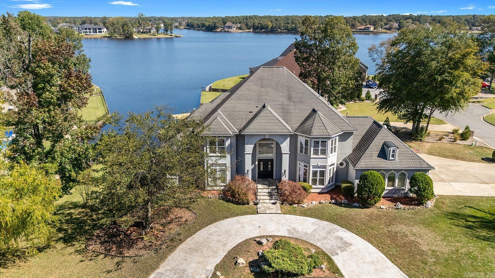 Stunning lakefront home on Hurricane Lake featuring four bedrooms, four full baths, and two half baths. A grand double staircase welcomes you into the formal living room with a striking fireplace and sweeping lake views. The gourmet kitchen offers a breakfast bar, separate dining area, and connects to a den with a projector and screen. The main level also includes an office, primary suite, two half baths, and a wet bar with a mini fridge. Upstairs youāll find three bedrooms, three full baths, and a spacious game room with a bar and mini fridge. Enjoy all new vinyl flooring on the main level and the serenity of a fully stocked lake, replenished monthly in spring and summer. Located within walking distance of the renowned Heart Hospital, this home blends luxury, convenience, and the best of lakeside living. Schedule your private showing today and experience all this home has to offer. SELLER IS PROVIDING $50,000 TOWARDS SELLER CONCESSIONS AND UPDATES.