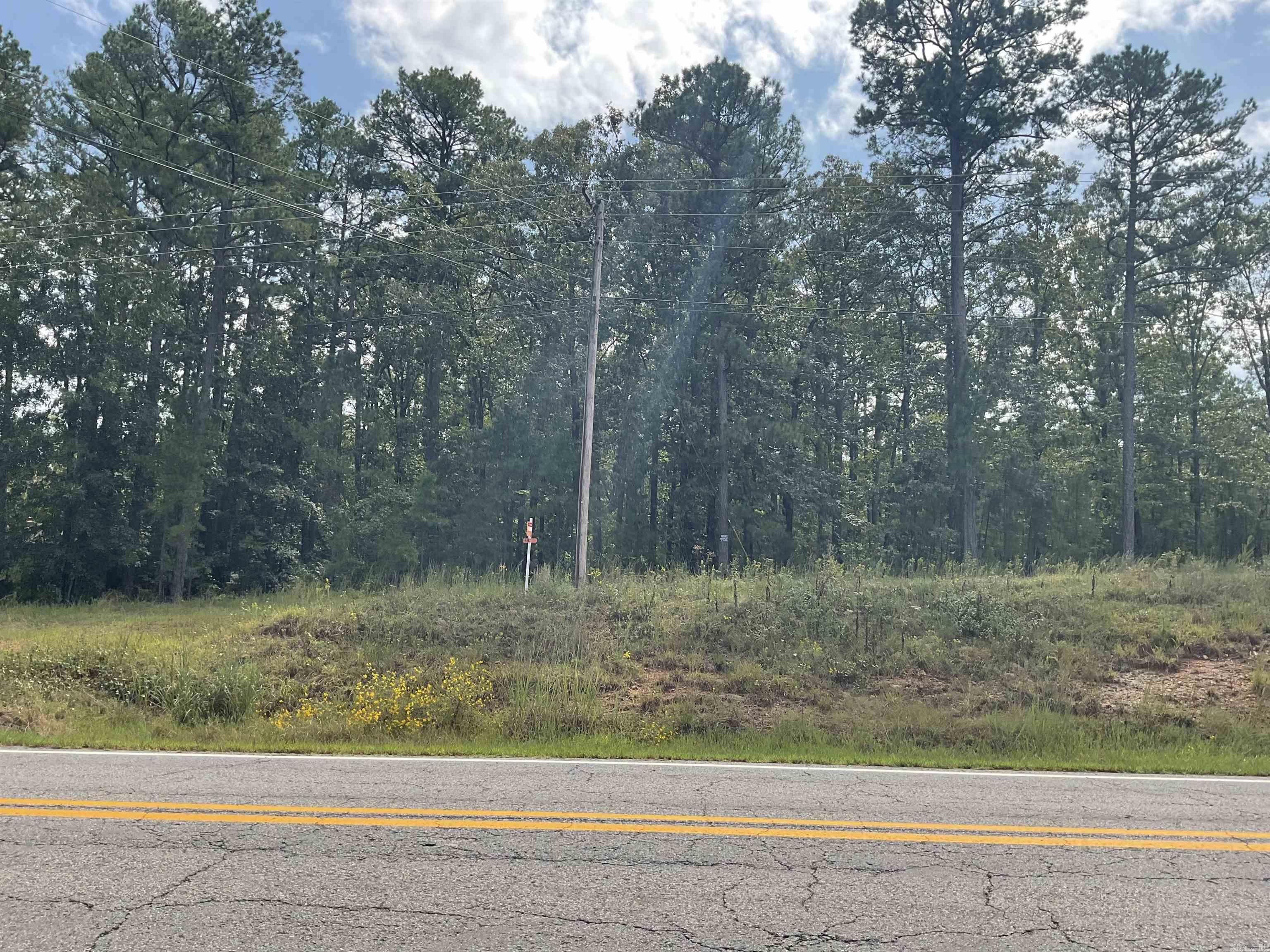What a beautiful one acre building site with 210 feet of Hwy 16 frontage. This great location has a very high traffic count and that's exactly what you need for a successful business site. Don't want a business then built back off the highway amid the forest trees that would block out sound and offer privacy. Nicely treed, level, driveway installed, all utilities there, only minutes from marinas, boat storages and lake access. Unrestricted area, no fees, no Covenants.