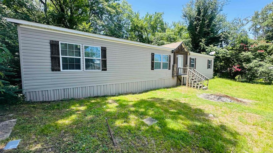 Just Like New! This 2015 custom-grade double-wide manufactured home offers the perfect blend of style, space, and affordability. Featuring 4 generously sized bedrooms and 2 full bathrooms, this well-maintained home is ideal for growing families.The chef’s kitchen is designed for entertaining, complete with ample counter space, built-ins, a large pantry, and an open layout that flows beautifully into the living and dining areas. A charming surprise awaits—a unique “secret” doorway leads into one of the bedrooms, adding a playful and creative touch.The spacious primary suite includes a double vanity, a relaxing garden-style tub, and a separate walk-in shower for added comfort and convenience.Conveniently located just across from Acme Brick and close to the highway, commuting is quick and easy. Don’t miss this opportunity to own a move-in ready home that feels like new—without the new home price tag!