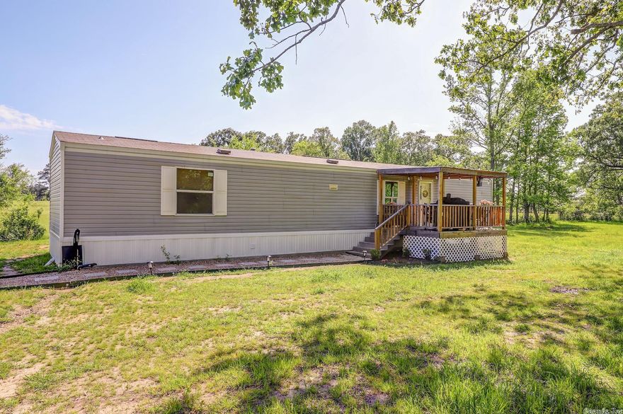 Oh you are going to love this cozy home in the country!  Just a quick drive from Texarkana to your little slice of paradise.  This single wide manufactured  home provides 2 bedrooms, 2 baths, an open kitchen and plenty of living space.  Sellers have added a covered front deck, NEW 40 gal. water heater, replaced storm door, nest thermostat, front door camera, kitchen sink & faucet, ice maker line & hi-speed internet.  The home has a 5 ton HVAC, city water, & septic system.  Additional acre is available. Storage building is not owned by the sellers and cannot convey.