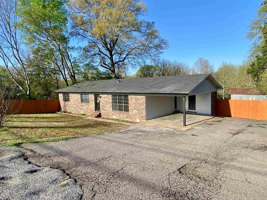 Recently updated and move-in ready, this 3-bedroom, 2-bath home sits on 1 acre at the edge of town with few neighbors, offering privacy and peaceful views. A covered back deck overlooks adjoining woods and pastures, while shade trees and a fully fenced yard add to the charm. Inside, you'll find a modern design with a spacious living room featuring built-ins, floating shelves, and vaulted ceilings with exposed beams. The eat-in kitchen is fully equipped with stainless steel appliances, solid surface countertops, bright white cabinetry, and a breakfast bar. Additional updates include a new roof, LED lighting, luxury vinyl flooring, and a custom-tiled shower with rainmaker fixtures and designer vanities in both bathrooms. The huge outbuilding provides plenty of storage, and the spacious laundry room comes with a like-new washer and dryer set. A flat screen TV and mount are also included — just move in and enjoy!