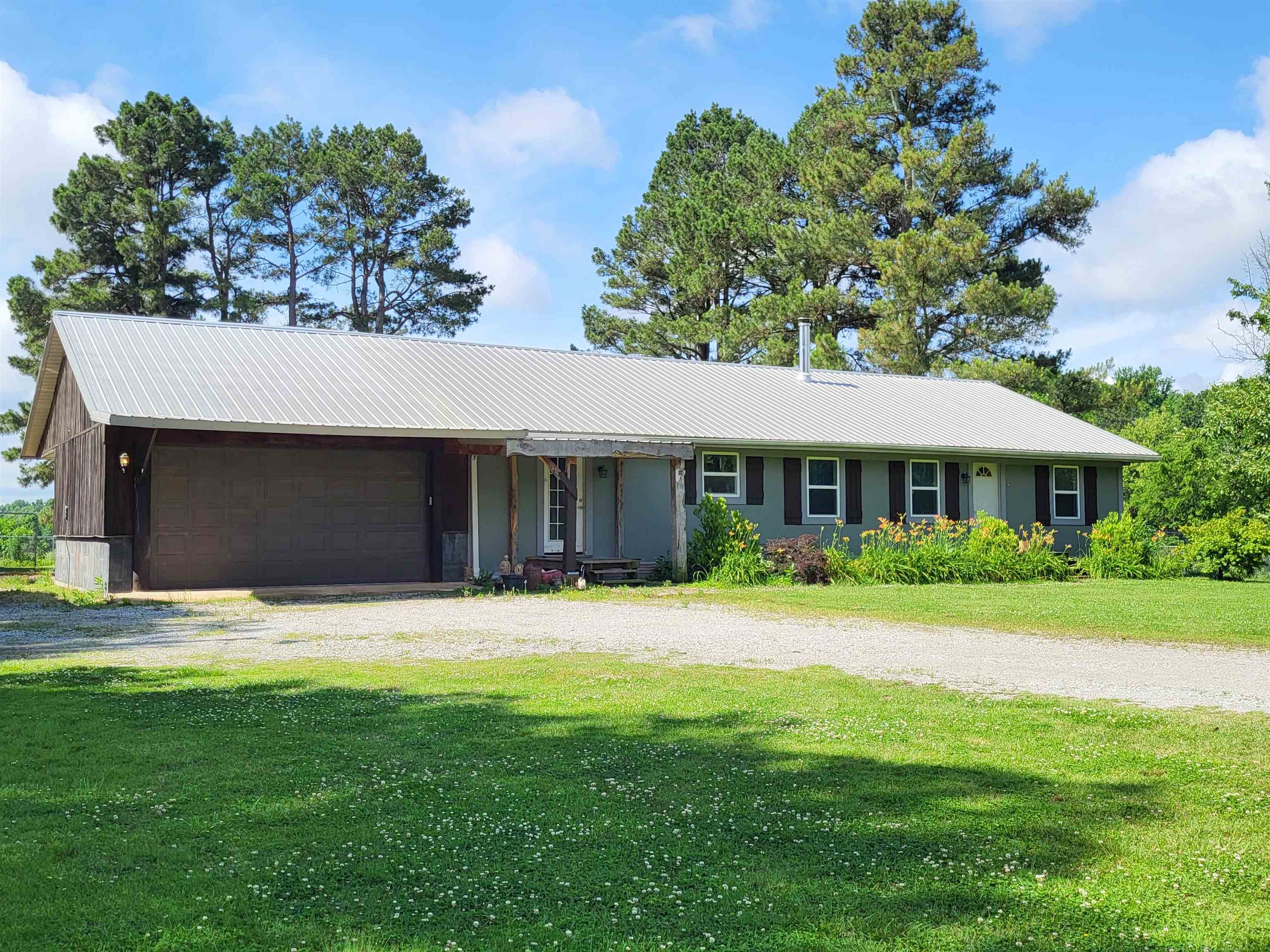 Craving seclusion in a beautiful country setting? Don't miss seeing this house! Newly renovated 3 bedroom, 2 bath home, large 30' x 60' workshop, and the neighbors have horses and cattle that are a pleasure to look at! The home features LVP flooring throughout with tile in the bathrooms, extra large living area, separate dining room, renovated kitchen with stainless steel appliances and a gorgeous farmhouse kitchen island. The kitchen backsplash is an attractive hexagonal penny tile. The primary bedroom as lots of storage with a demi-walk-in closet and a second large reach-in closet. The primary bath has a large walk-in shower and is very spacious. The guest bath is a large combination laundry room and bath that has a jacuzzi tub, adorable farmhouse vessel sink, and lots of cabinetry. Newer vinyl windows. Metal roof is approximately 8 years old. Off the dining room are French doors that lead out to the large covered deck and covered patio area. There is a second covered patio at the back of the property. Nice big yard with access to the workshop and a wonderful garden spot! There are peach, plum, and pear trees in the yard. The 30' x 60' workshop has electric, wood heat, and two