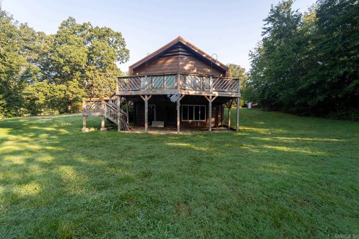 Looking for your own private escape in the heart of the Ozarks? Discover this beautifully updated 3-bedroom, 2-bath home tucked away on 7.48 secluded acres just outside Mammoth Spring, Arkansas. Surrounded by open pasture with no neighboring homes in sight, this property offers peaceful country living and modern comfort. The exterior features a tin barn with chicken coop and electric hookup—perfect for livestock or storage—as well as a smaller outbuilding with lights and a fridge. Step inside to find recent renovations throughout: fresh paint, new carpet and flooring, updated plumbing and lighting, and stylish fixtures. Upstairs, the master suite includes a walk-in closet with vanity and an additional closet for storage. The full bath is conveniently located just outside the bedroom. The kitchen is equipped with new appliances, under-cabinet lighting, and a garbage disposal. In the living room, enjoy the warmth of a fireplace and take in sweeping views from large windows and a sliding glass door. A spacious laundry/mudroom with hall tree provides space for coats, shoes, and bags. Downstairs, find two additional bedrooms—one with a walk-in closet and the other partially undergrou