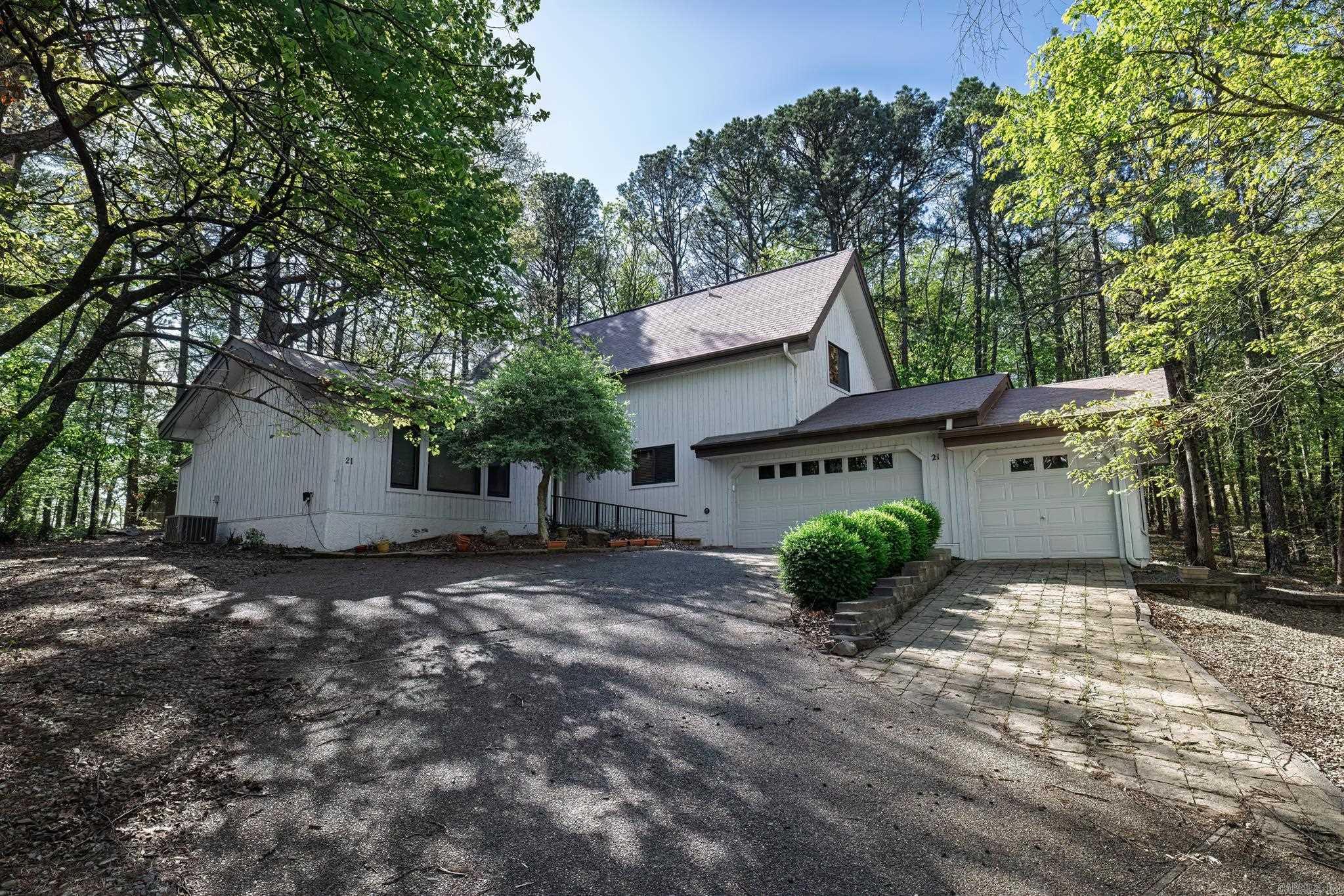 This custom built home is a one of a kind. You will enjoy spacious living room with a wall of windows overlooking wooded yard. The living area has soaring ceilings, propane stove, and open to the formal dining room and kitchen. The kitchen is stunning with granite counters, custom cabinetry, tons of space, ceramic backsplash, stainless appliances. Laundry room off kitchen. Primary suite in on entry level and has a spa bath with soaking tub and shower. There is a large walk in closet and built in desk and cabinetry in bedroom. The upper level has a loft and a bedroom and bath. Or use the loft as a bedroom and you have two bedrooms upstairs. This home also has a 3 car garage. In this price range this home stands out! Hot Springs Village is a 26,000-acre gated community with 11 lakes, 9 golf courses, white sand beach, hiking trails, pickle ball, fitness center, indoor and outdoor pool, tennis and SO MUCH MORE. One time POA buy-in fee $2000 due at closing.