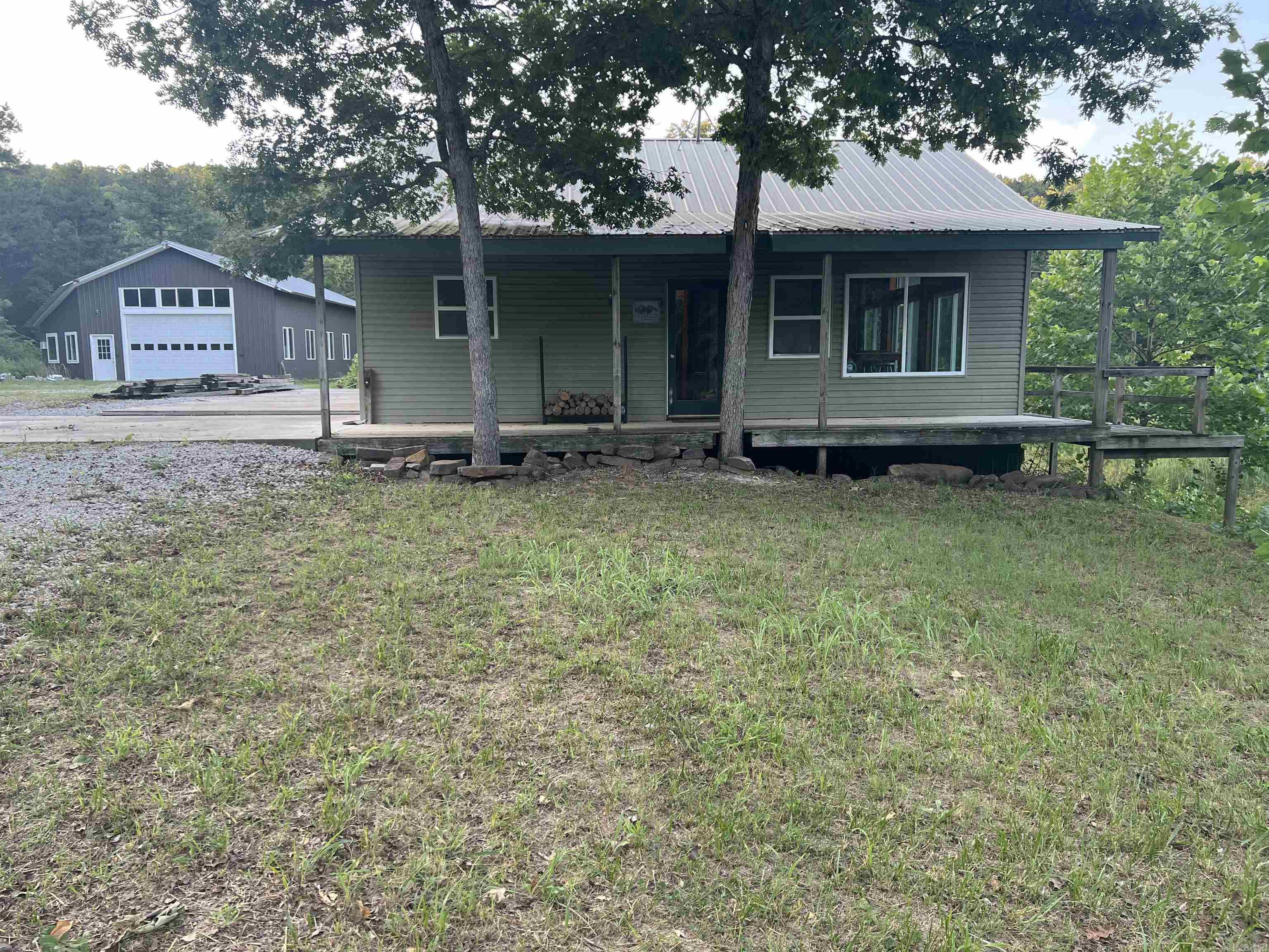 PRIVATE secluded home plus a 62'x40' guest house/workshop on 60 acres!!! Very close to the Buffalo River National Park. This comfortable country home features 2BR-1BA, wood stove heat, cathedral ceilings, loft area, walkout basement bedroom, 3 decks, 8x32 covered porch overlooking the year-round pond, and calming country views. MUCH more than an expansive workshop, the 2,480 SF shop building is rustically finished with 3BR-1BA, LARGE loft, wood stove, lovely wood walls, utility room, partially finished kitchen room, and plenty of room for guests!!! 60 acres includes approximately 5 acres of pasture, LOTS of wildlife, and a YEAR-ROUND SPRING that is piped and gravity flows into the house for water (home also has a water well). Plus a 16x24 storage barn with 15x24 attached lean-to. This is a Preppers dream property.