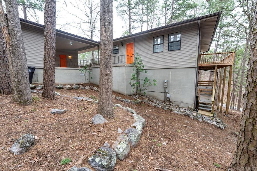 Perched in the tree tops you will enjoy the view from all new expansive decks that wrap around the entire back of the home on two levels.  The full glass sliding doors offer quick access to the decks and plenty of sunlight from the main living area, master bedroom and secondary bedroom.   All three bedrooms, a laundry room and a full bathroom are on the lower level of the home.  Step over from your two car carport, great for outdoor entertaining,  to the front entry that opens into a large open flowing living room that connects to the large kitchen with island and bar area and a full bathroom on the main level.  This unique home offers 1800 sq ft of living space perfect for a family to enjoy year round or would make a fantastic vacation destination.  The home comes fully furnished and is ready for your family or would make a great short term rental as an investment. Minutes from several lakes, steps away from miles of trail systems and just a short drive to one of seven amazing golf courses!  Hot Springs Village is filled with fun for the entire family in one of americas largest resort communities and just 18 miles from Historic Hot Springs bath house row and Oaklawn race track.