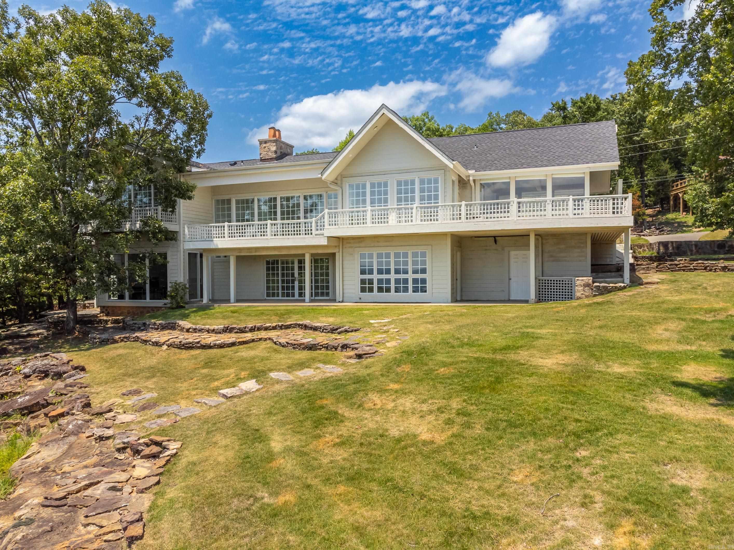 The subject dwelling is a very good quality custom built single family residential dwelling sitting on two very large lots with spectacular lake views!! The main upper level has access from a front foyer via a covered porch along with access through the attached garage as well as enclosed patio areas along the west and east sides of the house. The upper level has a large living area with fireplace, a custom kitchen / dining area, a large master suite with a separate sitting area, his and hers bathrooms, and closet spaces. Other rooms include a laundry space, guest bathroom, as well as an entry foyer and multiple closets. The upper level has vaulted ceilings with custom tongue and groove ceiling finishes with sold wood beams. The walls are taped and painted drywall with custom wood trim. The flooring is primarily hardwood with some tile, brick, and carpet in some areas. The kitchen features custom cabinetry with numerous built-in storage components and good quality appliances. There are fireplaces in the living room and master suite area. The lower level has a large open office / multi-use space with access