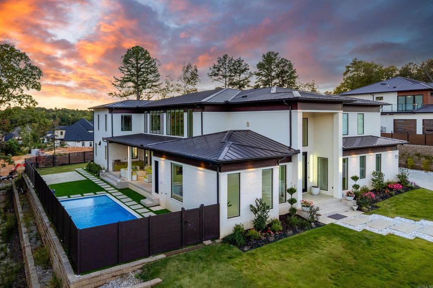 Completely custom-built, one-owner modern luxury home located in Chenal Valley’s prestigious gated Orle neighborhood in West Little Rock. This exceptional residence showcases high-end finishes and cutting-edge design throughout, featuring acrylic doors, frames, and cabinetry, a grand entryway, private office, and dedicated work area. The gourmet kitchen boasts dual islands, a separate prep kitchen, and seamless integration with the living spaces. Additional highlights include an impressive media room, bonus room, and all bedrooms with en-suite baths. Outdoor living is equally stunning with a resort-style pool surrounded by turf, covered patio with outdoor kitchen, pool half bath, and outdoor shower. Other amenities include solar panels, Tesla inverters, built-in holiday lighting in the soffit, a home gym area, three-car garage, and full home automation. A true statement of modern luxury and craftsmanship in every detail.