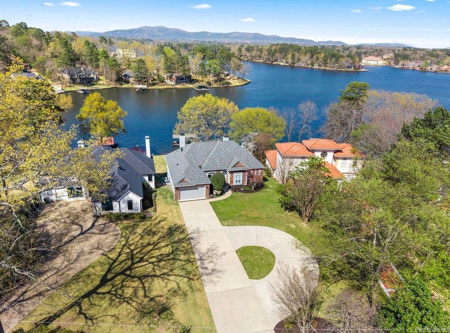 This beautifully remodeled 5 bed, 3.5 bath home offers spectacular lake views from both upper decks & lower patio in one of the most sought-after Lakeside School District locations on Lake Hamilton. With over $250,000 in upgrades, experience waterfront luxury in this spectacular two-story, 4190 sqft home. The moment you walk thru the door graceful elegance & a view straight out to the water will take your breath away. The carefully designed living space with hardwood floors and chef's kitchen is crafted to exude sophistication and charm at every turn with 2 informal living areas, 2 kitchens, a lavish primary ensuite, spacious guest rooms, office space, loads of storage space, & bonus space to boot! Outside lakefront luxury includes a deck with panoramic views and a private 2-stall covered dock with swim deck offering exclusive lake access and the perfect launching point for exploring the vast expanse of Lake Hamilton! Beyond its potential as a nightly rental, this property seamlessly transforms into an idyllic family vacation home or a luxurious primary residence that effortlessly adapts to a variety of lifestyles! Ask to see the extensive list of upgrades & schedule your showing!