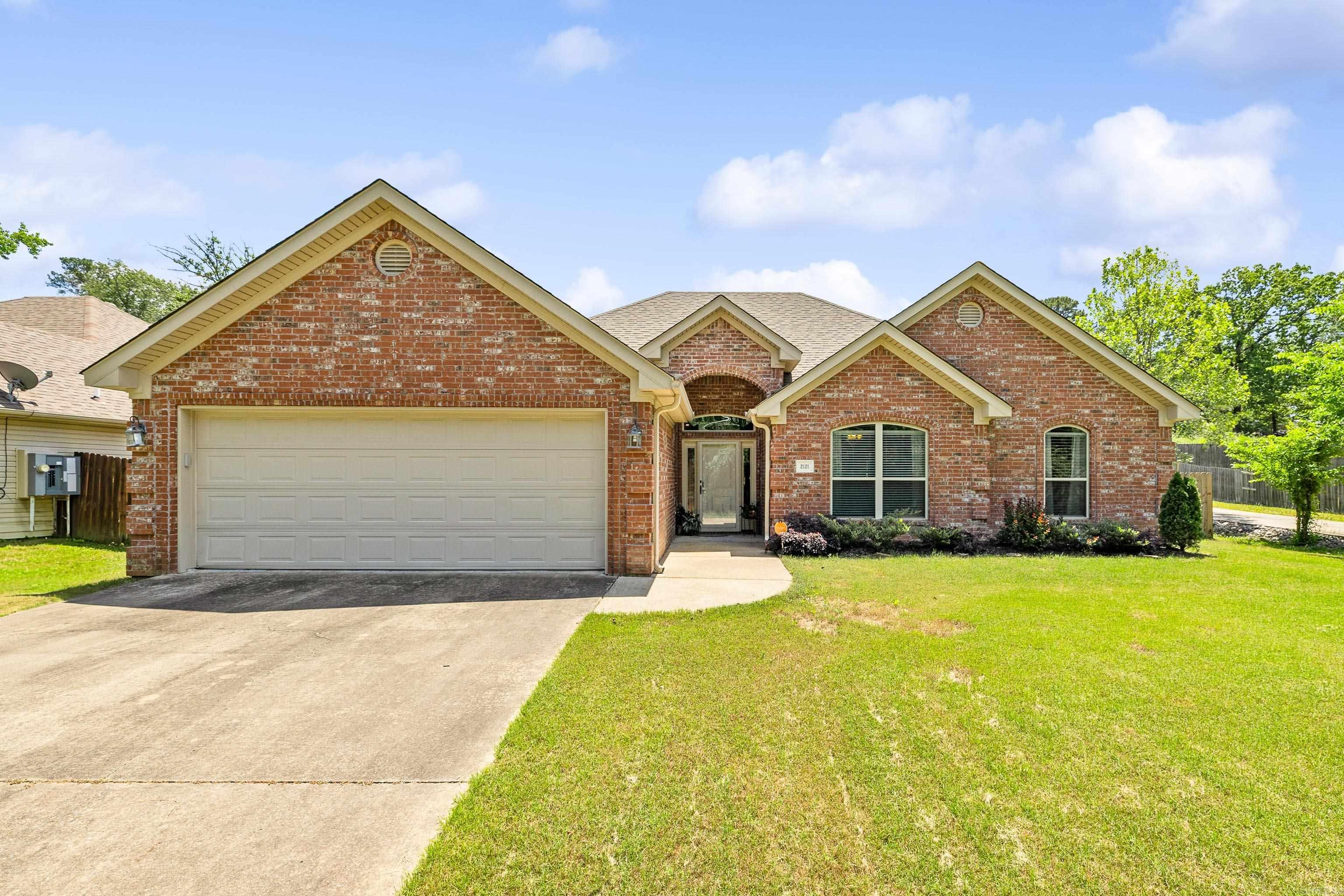 UPDATED HOME IN THE HEART OF BRYANT WITH STUNNING COVERED DECK! Charming, beautifully maintained, and perfectly located—this home has it all. Featuring a desirable split floor plan, 12 ft ceilings, and new light-colored wood floors throughout. The open-concept living area includes a warm wood-burning fireplace and a stylish kitchen with granite countertops, a breakfast bar, and stainless steel appliances. The private primary suite offers a peaceful retreat with a tray ceiling, double closets, and dual vanities with granite finishes. Step outside to a fully fenced, beautifully landscaped backyard with a covered deck with outdoor grilling area and soaring cathedral ceiling with wood detail, not to mention extensive landscaping—perfect for relaxing or entertaining!