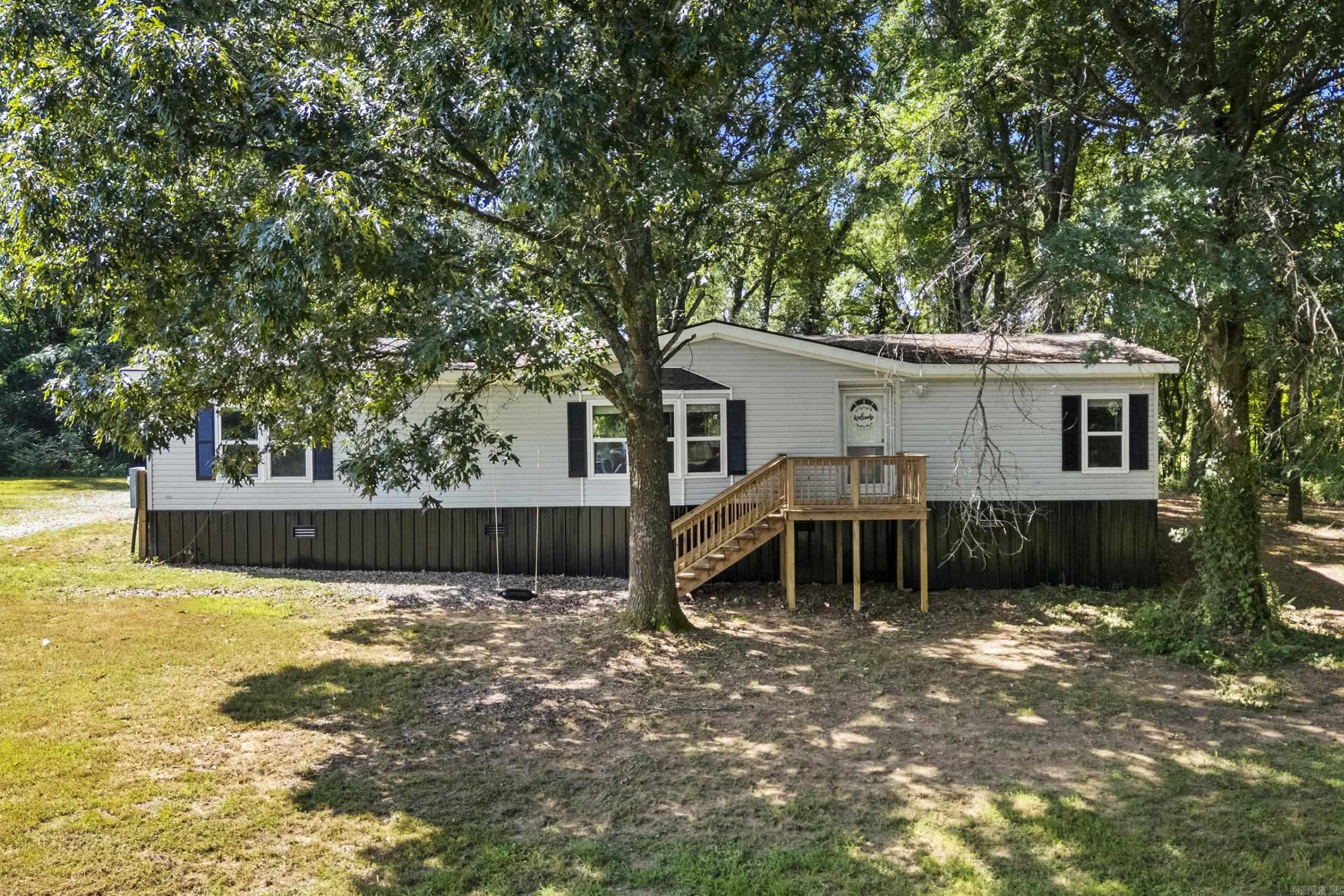 Nice home in a beautiful wooded setting just minutes from Searcy, the Bald Knob National Wildlife Refuge, and the Little Red River. This doublewide mobile home is on a permanent foundation and has been recently updated with a new roof, HVAC unit, plumbing, and energy-efficient windows.Inside, you'll find fresh paint, vinyl plank flooring, modern light fixtures, and stainless steel appliances. The split floor plan provides privacy, with a spacious primary suite featuring a large walk-in closet, soaking tub, and a separate walk-in shower. Two additional bedrooms offer great closet space and share a full bath with a tub/shower combo.Enjoy peaceful mornings and evenings on the front and back porches. A concrete-floored storage building offers extra storage space.