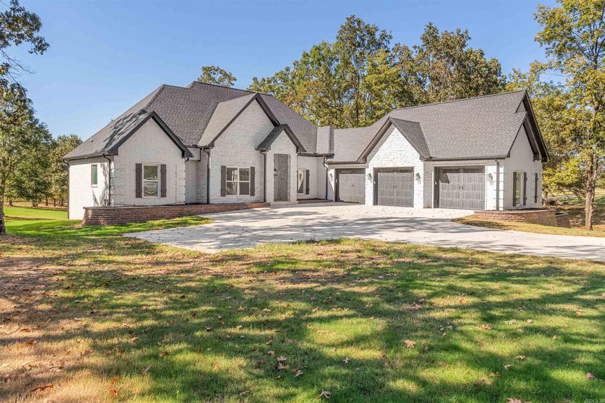 This brand-new home is located in the Terra Hills subdivision and is situated on nearly 3-acres of land. Filled with trees and beautiful countryside, this lot has waterfront access to the pond photographed. When walking through the front entrance you're met with high ceilings and large windows that show off the beautiful landscaping and covered porch in the back. The main floor kitchen is separated from the living area by a center island with quartz countertops. A few special features include the professional grade gas stove as well as an oversized double-sided refrigerator & freezer, all in close proximity to the butler's pantry. There are bricked gas fireplaces on each floor. The master bedroom on the main floor features two master closets, a large master bathroom with an oversized shower that has double shower heads on each side, a clawfoot soaker tub, and his and hers sinks.