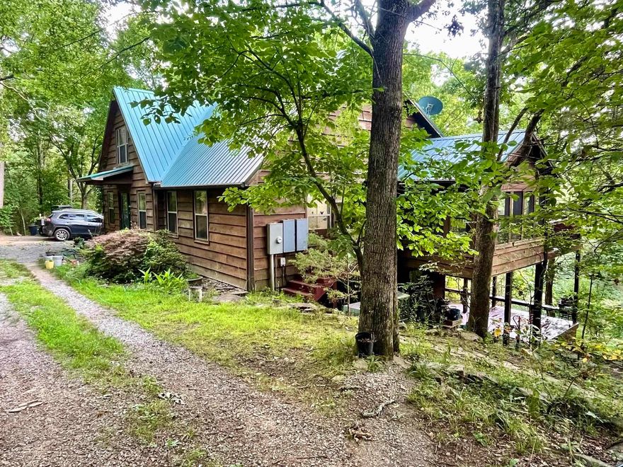 Tucked deep into the forest and nestled along the scenic banks of Cadron Creek, this stunning 3-bedroom, 3-bathroom mountain retreat offers a rare combination of natural beauty, privacy, and comfort. Designed to blend into the landscape, the home is enveloped by towering oaks, hickory, and cedar trees, with over half a mile of Cadron Creek frontage and nearly a full mile of seasonal creeks winding through the property. This thoughtfully crafted home features two separate living areas and a loft. Each living area has its own kitchen and cozy wood-burning fireplace, making it ideal for multi-generational living or hosting guests. This property offers the ultimate in natural seclusion, yet is only minutes from shopping, schools, and hospitals. Whether you're seeking a quiet primary residence, an inspiring retreat, or a one-of-a-kind family legacy property, this Cadron Creek hideaway delivers an experience like no other.