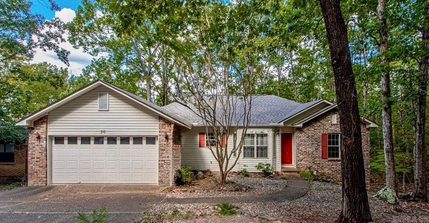 Welcome to this inviting 3-bed, 2-bath home tucked in one of the more established areas of Hot Springs Village.This property features distinctive architectural details and an abundance of windows that fill the home with natural light and offer beautiful wooded views from nearly every room!!  The primary suite provides comfort and privacy, while two additional bedrooms offer flexibility for guests, family, or a home office. You’ll also appreciate the convenience of the attached two-car garage for parking and extra storage.  Located just two miles from the West Gate, you’ll have quick access to shopping, dining, and everyday essentials. Outdoor enthusiasts will love the nearby walking trails and the ease of exploring the Village right from home. Residents enjoy access to all the incredible Hot Springs Village amenities private golf courses, lakes, tennis, pickleball, fitness centers, and more all within a secure, welcoming community.