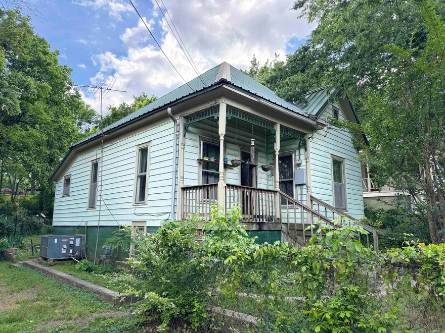 Welcome to this inviting 3-bedroom, 1-bathroom home offering 1,092 square feet of comfortable living space. Originally built in 1925 and thoughtfully remodeled in 1970, this home combines timeless charm with newer updates. 10' ceilings!  Step inside to find carpet over original hardwood floors that showcase the home's rich history, paired with an open floor plan that creates a spacious and welcoming atmosphere. The kitchen is equipped with a gas stove, refrigerator (included), and a convenient microwave—perfect for both everyday living and entertaining.  Enjoy peace of mind with a durable 15-year-old metal roof and a fully fenced yard, ideal for pets or simply enjoying your outdoor space. The large backyard offers endless possibilities, from gardening to gatherings, and includes a 10x12 storage shed for all your tools and toys.  Relax and unwind on the beautiful front porch, perfect for morning coffee or evening conversations.  Whether you're a first-time homebuyer, downsizing, or investing, this property offers a rare blend of character, functionality, and value.  Schedule your private tour today—homes with this kind of charm don’t stay on the market long!