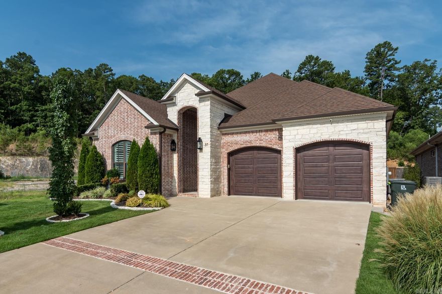 Welcome to 37 Belles Fleurs Circle! This wonderful one-story home located in a prime location in "like new" condition with high-end amenities and features which blend comfort, style, and convenience. Beautiful wooden front door welcomes you  into an inviting foyer presenting a barrel-vaulted ceiling adjacent to the half bathroom. The spacious open floor plan seamlessly connects the great room, kitchen and dining room creating a warm and inviting atmosphere. The great room features a fireplace with gas logs, large windows for natural light, and a brick accent wall. The gourmet kitchen offers quartz countertops and stainless appliances including a GE gas cooktop, vent-a-hood, double ovens, dishwasher, microwave and a walk-in pantry. The primary bedroom offers a tray ceiling with accent lighting, bathroom with free-standing soaker tub, walk-in shower and private water closet. The primary closet features convenient access to the laundry room with sink and mud room. Two additional bedrooms offering a hall bathroom positioned between them. The private backyard offers a fireplace, screened-in porch with living and dining space and a fenced backyard.