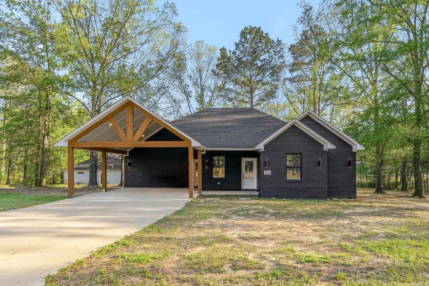 Brand new construction with a sleek, modern design, this owner-built home began in 2023 and was completed in 2025, offering the benefit of fresh finishes and thoughtful craftsmanship throughout. Tax records may reflect the original construction start date. Featuring 4 bedrooms and 2 bathrooms across approximately 1,808 sq ft, the layout is both functional and refined, with flexibility for the 4th bedroom to serve as a private office or study.  The open-concept living area showcases vaulted ceilings with exposed beam detail and a statement fireplace insert, creating a warm yet contemporary focal point. The kitchen is designed for both everyday living and entertaining, featuring custom cabinetry, a large island, modern countertops, tile backsplash, and a walk-in pantry with built-ins.  The primary suite offers a spa-inspired feel with a walk-in tiled shower, dual vanities, and clean, modern finishes. Additional highlights include a dedicated laundry space, ample storage, and cohesive finishes throughout.  Situated on .33 city lot, the exterior offers strong curb appeal with a covered carport and inviting entry.  Tax record contains discrepancy in sq ft, see blueprint for accuracy.