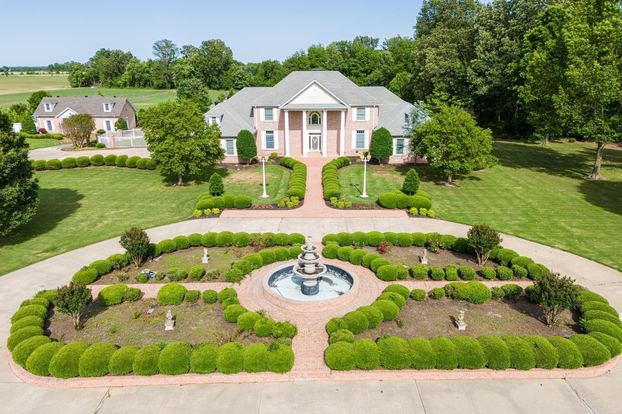 Welcome to your sanctuary, where luxury meets tranquility on nearly 16 acres of manicured land. This magnificent 4-bedroom, 5 1/2 bathroom estate is a testament to refined living, offering a lifestyle of unparalleled elegance and serenity. From the moment you pass through the gated iron/brick entry and are greeted by the lush landscaping and center fountain, you'll feel like you've entered a world of your own, where every detail has been carefully crafted to indulge your senses and elevate your experience. Step inside to discover a chef's kitchen, outfitted with granite countertops, high-end appliances, and a gas range w/ built in griddle. Adjacent, an expansive dining area sets the stage for memorable gatherings, along with a breakfast area and sunroom across the back allowing tons of natural light to cascade the room, while oversized windows frame breathtaking views of the surrounding landscape in the back yard as well. Retreat to the primary suite, a haven of relaxation and indulgence, where a vaulted sunroom awaits, bathed in natural light and warmed by a cozy gas log fireplace. Unwind in the en-suite bathroom, complete with double closets offering ample storage