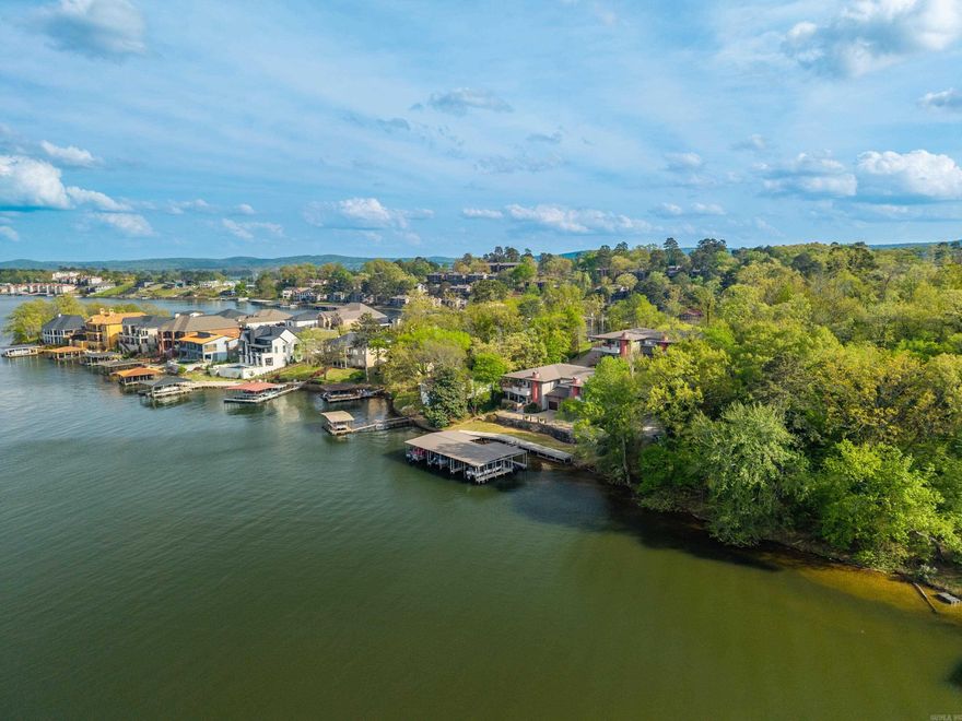 Rare opprtunity to join this exclusive condo development on Wilson Point on Lake Hamilton. The spacious unit offers 2190 square feet of energy efficency with an open concept large kitchen and living room plus office space.  The high ceilings are accented with wood for a gorgeous elevated touch, and the hallway leads you to a stunning mural in the reading nook.  There are 3 bedrooms, 2 full bathrooms plus a half bath and separate laundry room. The primary suite has a large walk in closet and oversized bathroom.The unit also has as garage for protected parking plus extra storage. Enjoy maintenance free linving while soaking up the lake views and water feature from you covered patio or cozying up to the fireplace during the winter. This is not your average condo!