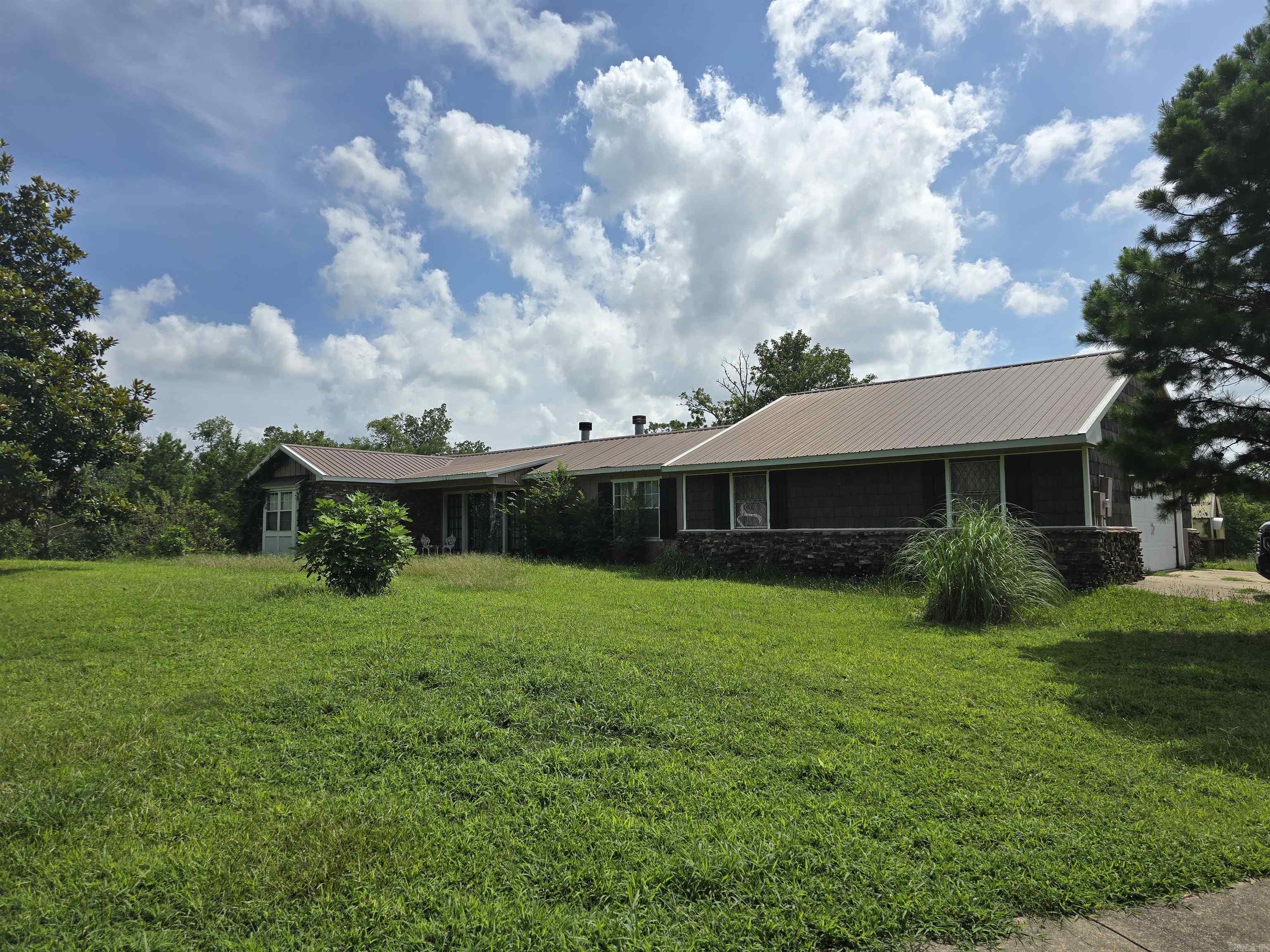 Discover the perfect blend of country charm and city convenience in this delightful 2-bedroom, 2-bathroom home. Nestled on a spacious lot, this property offers a serene escape while still being remarkably close to everything you need. Step inside and find a comfortable living space, ideal for relaxing or entertaining. The primary bedroom boasts an absolutely huge walk-in closet, providing ample storage. Car enthusiasts and hobbyists will rejoice at the attached, oversized 2-car garage, offering not just parking but also a dedicated work area for all your projects. The true magic of this property unfolds in the backyard. Imagine unwinding by your very own private pond, a tranquil backdrop for everyday living. Overlooking the water is a charming studio-style cabin, perfect for a home office, art studio, guest retreat, or simply a peaceful hideaway. An additional storage building ensures you'll have a place for all your tools and toys. This unique home offers the feeling of being "out of town" with its peaceful setting, yet it's incredibly convenient to amenities. Don't miss the opportunity to make this hidden gem your own!