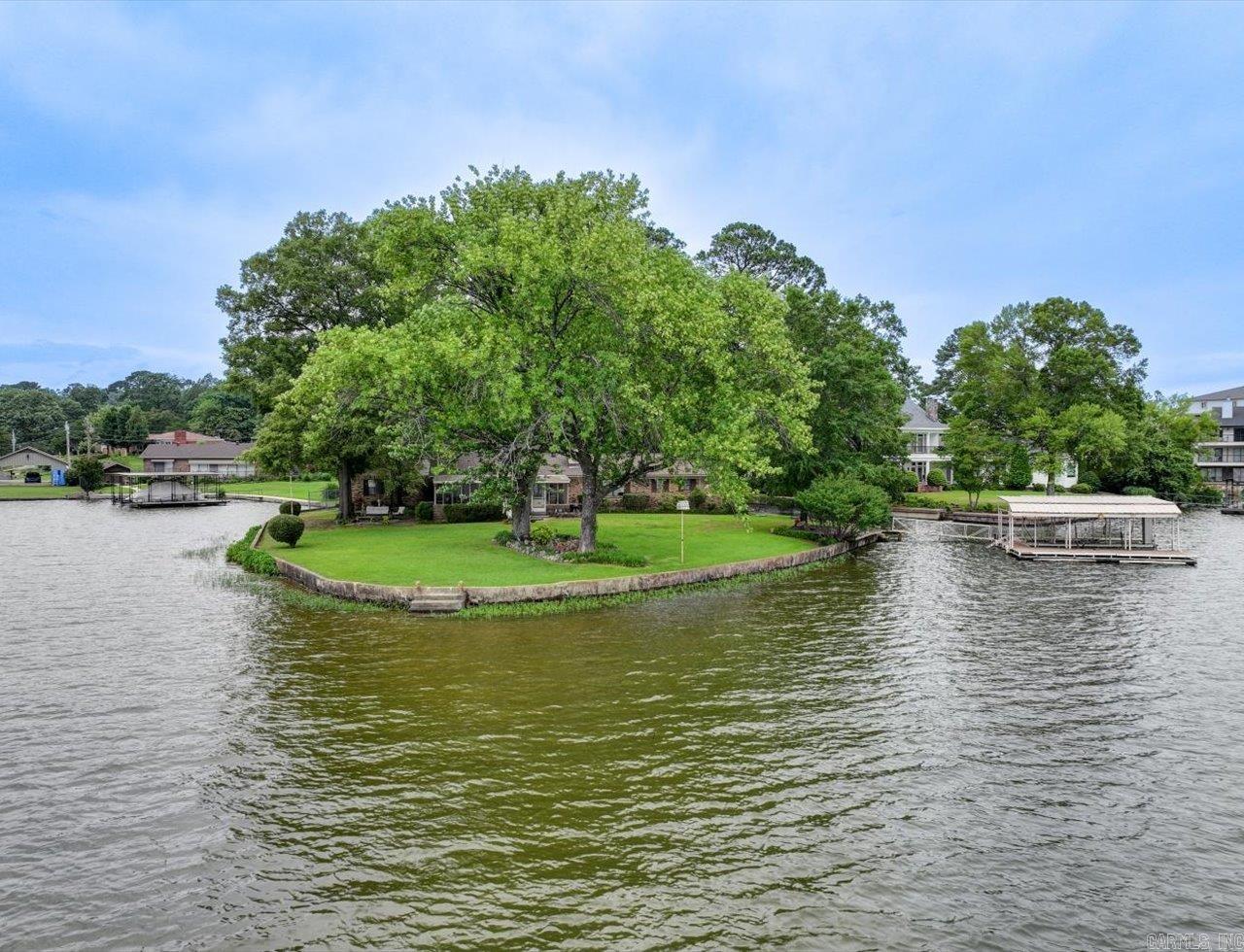 RARE OPPORTUNITY TO OWN A FULL-POINT PROPERTY ON LAKE HAMILTON! Over 465 feet of prime lake frontage with 2 boat slips and dock, on a premium peninsula, with unobstructed, panoramic views in every direction. Wake up to peaceful sunrises and unwind with vibrant sunsets from your deck, screened-in porch, or boat. Expansive windows throughout the home bring the breathtaking lake views inside, creating a seamless connection with nature. With a formal living room and spacious family room that opens to a screened-in porch, thereās ample space for entertaining or simply relaxing with family on those perfect lake days. Whether youāre seeking a vacation retreat, short-term rental investment, or full-time residence, this rare point property offers unmatched peace, privacy, and natural beauty. Plenty of space to expand, add a pool, outdoor fireplace, or whatever you can imagine. More than just a lakefront home - here's a chance to own a truly unique piece of real estate where the value lies in the extraordinary land and shoreline - in Lakeside School District. Opportunities like this donāt come often. COME AND SEE! Agents - please schedule all showings through Showing service.