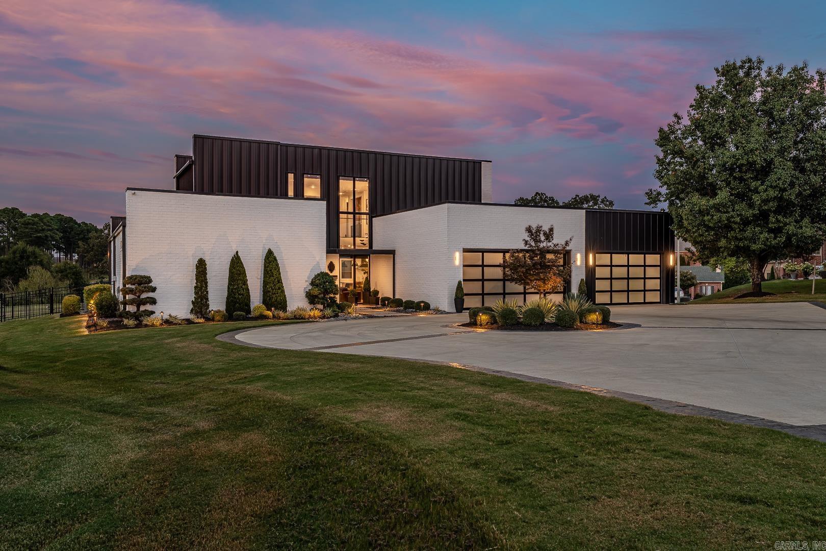 Renovated and expanded in 2024 by Westbrook Kitchens & Baths, this residence grew by nearly one-third with a new wing including a third garage, dedicated laundry room, and fourth bedroom currently serving as an office with adjoining glass-walled gym and full bathācreating two main-level primary suites. Updated by Sound Concepts, the home is fully automated, low-maintenance, and travel-friendly. Offering 4 bedrooms, 3.5 baths, and 4,767 sq ft, the layout includes two bedrooms upstairs with a shared full bath. The three-car garage is finished to showroom standards with epoxy flooring, custom cabinetry, and frosted glass-paneled doors. Architectural highlights include a double-height glass entry, mirrored fireplace in the living room, and seamless flow to the screened porch with golf course views. The kitchen centers on a dramatic Dalmata marble waterfall island with professional Smeg and Miele appliances, integrated refrigeration, and a catering pantry. Wide-plank floors, Toto fixtures, and curated finishes unify the design.