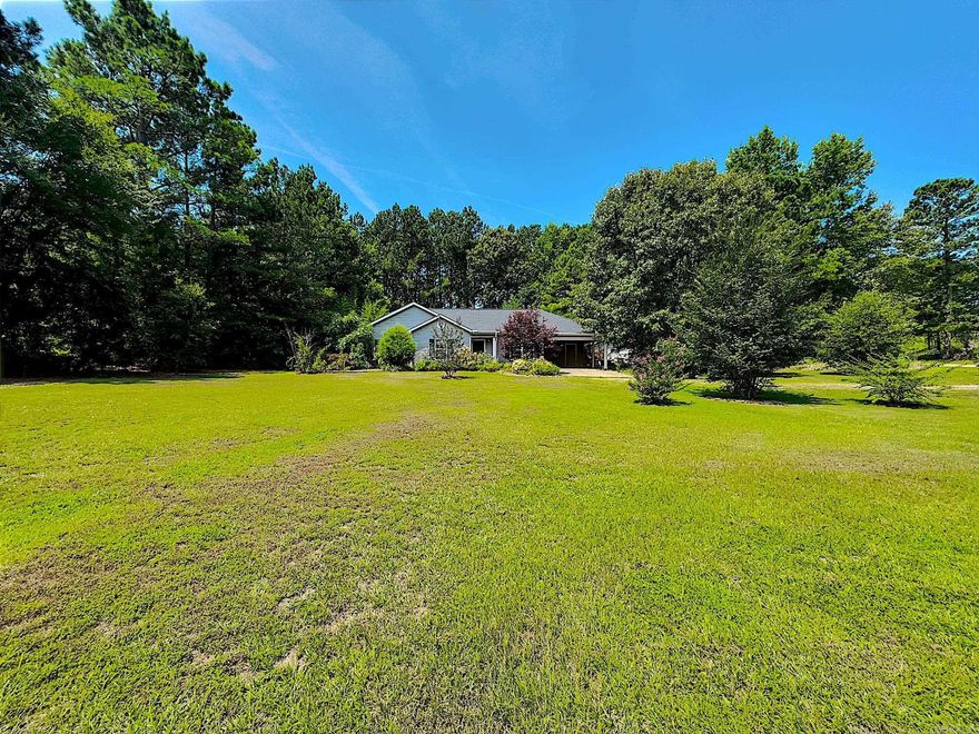 Nestled in a quiet subdivision, this charming 3-bedroom, 2-bathroom home sits on 1.31 acres of lush landscaping, featuring abundant flowering plants and serene bamboo groves. A spacious kitchen awaits you, perfect for cooking and entertaining. Speaking of entertaining, you will enjoy the covered back porch overlooking the fenced-in yard for the 4 legged family member. The laundry room doubles as a saferoom for added security during storms. A large shop with a roll-up door and side entry offers ample storage or workspace. Recently installed in June 2024, the new roof ensures durability and peace of mind. This property blends tranquility with practicality, ideal for comfortable suburban living.