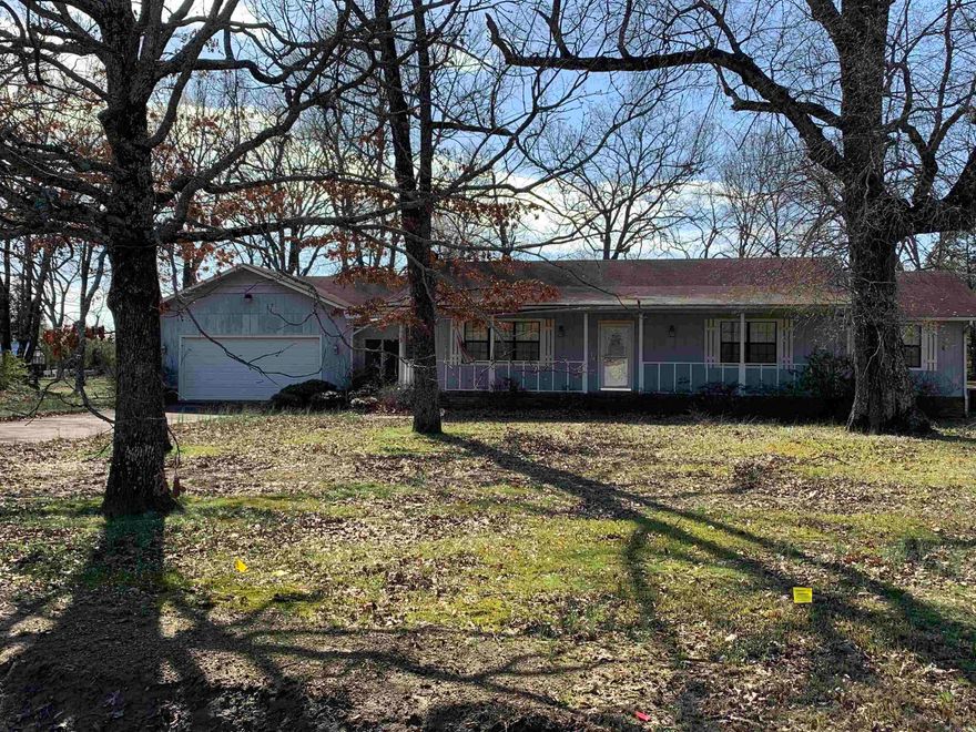 Home sitting on approx. 1.66 acres.   This home is close to schools and shopping.  Kitchen features great cabinet storage, counter space and eat in area.  There is a breezeway to the garage off the kitchen.  Nice covered front porch and beautiful established trees.  AGENTS see REMARKS!