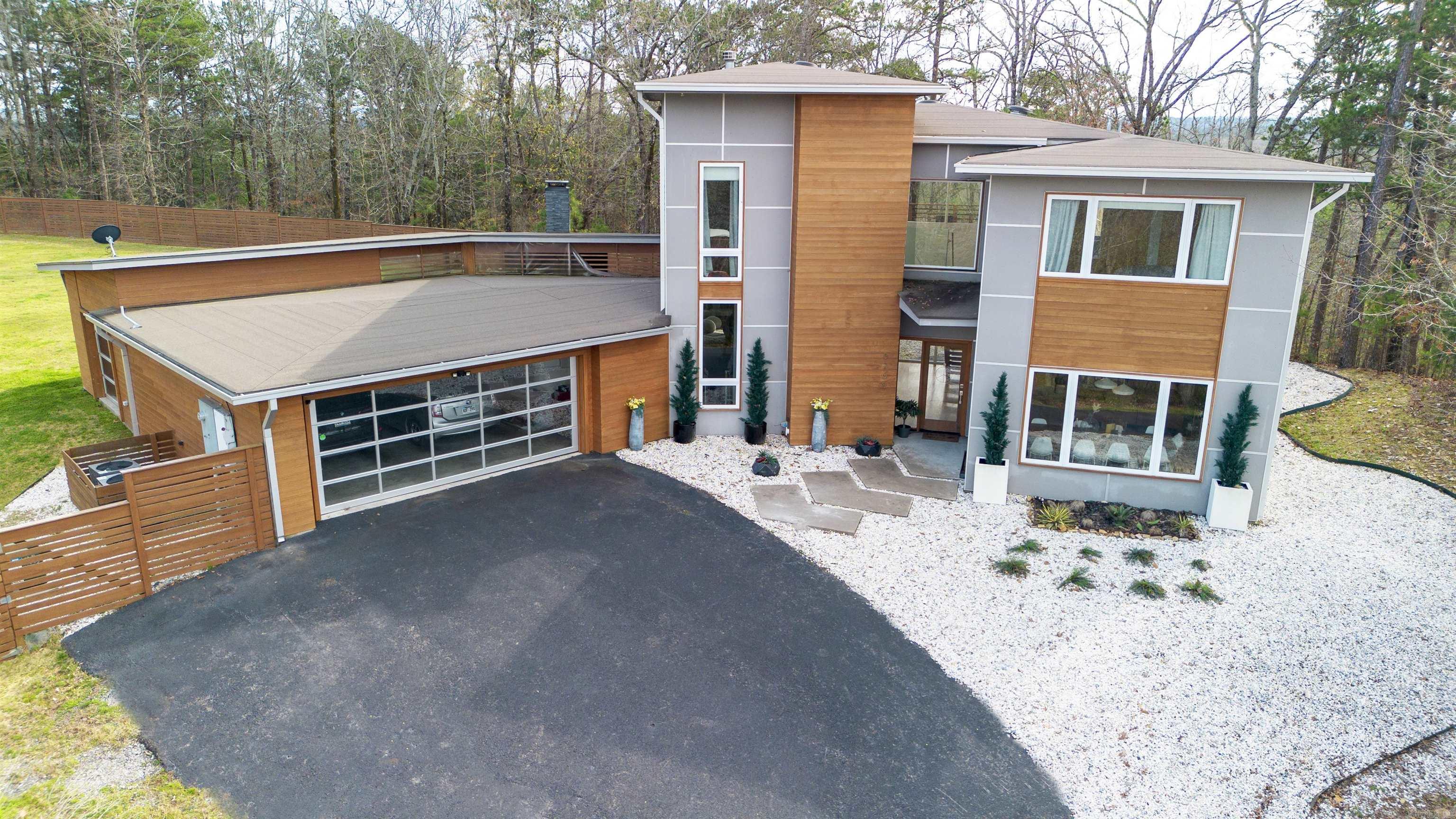 One of a kind modern gem situated atop a private wooded lot of 5+ acres featuring a large pond, privacy fenced level back yard with multiple entertaining spaces including basketball/tennis court and covered veranda with large fireplace. Grand front entryway with floor to ceiling windows overlooking tranquil wooded setting. High end features throughout including hardwood floors, & chef's kitchen with SS appliances, large breakfast island, granite countertops, tons of cabinetry, & large pantry. All bedrooms upstairs including impressive primary suite with spa-like shower/soaker tub, great built-in closet storage, and private balcony. Oversize garage includes storm shelter, & bonus area great for hobbyist or home gym. Agents see remarks for additional information.