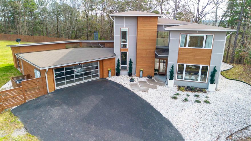 One of a kind modern gem situated atop a private wooded lot of 5+ acres featuring a large pond, privacy fenced level back yard with multiple entertaining spaces including basketball/tennis court and covered veranda with large fireplace. Grand front entryway with floor to ceiling windows overlooking tranquil wooded setting. High end features throughout including hardwood floors, & chef's kitchen with SS appliances, large breakfast island, granite countertops, tons of cabinetry, & large pantry. All bedrooms upstairs including impressive primary suite with spa-like shower/soaker tub, great built-in closet storage, and private balcony. Oversize garage includes storm shelter, & bonus area great for hobbyist or home gym. Agents see remarks for additional information.