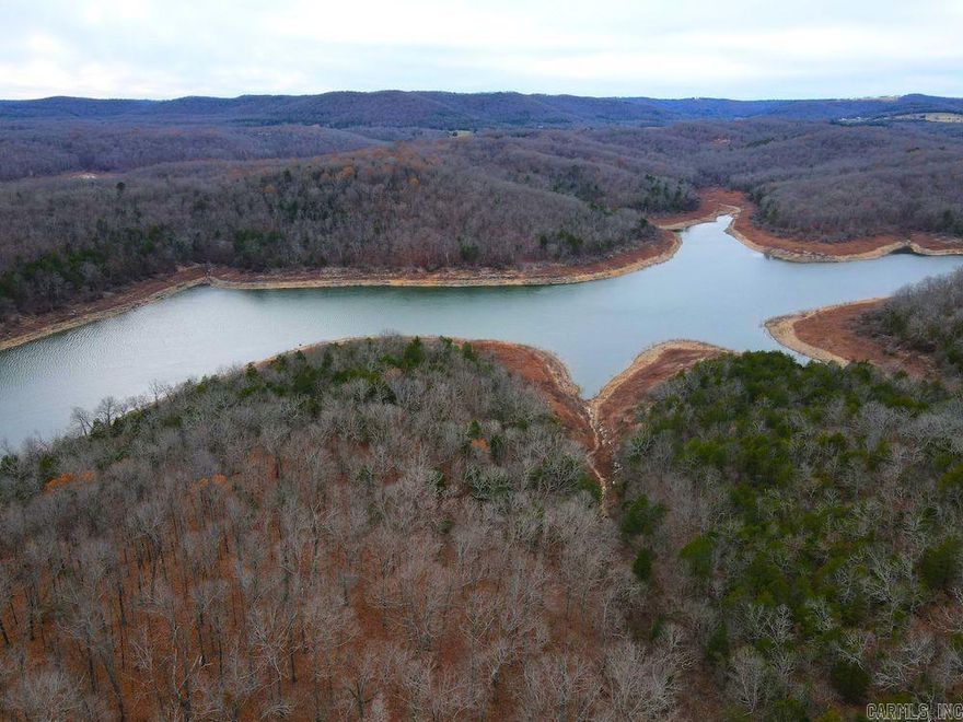 Remarkable land with multiple options fronting the famous Bull Shoals Lake doesn't come up very often. This unique dream site is sure to impress. Located just West, across the lake, from the city of Bull Shoals, AR, you are near many restaurants, lodging, recreational opportunities, and more. This region is also known for its large whitetail deer, turkey, black bear, and other large and small game. The rolling terrain is accessed easily off the gravel county road and offers many options for development, building, or virtually any other venture. The property lays out with several ridges that gently cascade down to the water's edge of Bull Shoals Lake and present options for additional hunting, camping, hiking, and phenomenal fishing. The largemouth bass, catfish, crappie, smallmouth bass, walleye, and other fish species all call this renowned lake home. This stand of mature and marketable timber is stunning and gorgeous and offers not only aesthetically pleasing beauty but also some added cover and food for the deer and turkey. Several ravines have rock outcroppings, seasonal waterfalls, and pure ozark beauty in their own unique right.
