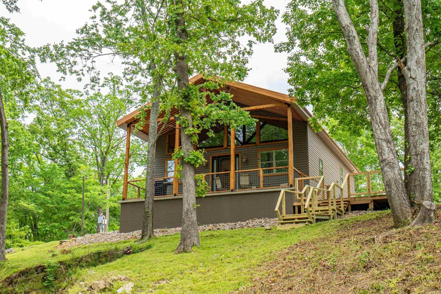 Cabin Life Meets Lake Living at Burchwood Bay!  Dreaming of lakefront serenity with a cozy cabin vibe? This is it. Nestled on 1.371 wooded acres in the heart of beautiful Hot Springs, AR, this charming 2 bed, 2 bath cabin delivers the perfect mix of rustic charm and modern comfort.   Step inside and you'll immediately feel the easy-breezy magic of open-concept living, tall ceilings, and natural light pouring in from every angle. It’s bright, it’s airy—it’s your escape from the everyday.  But the real magic? It’s waiting outside.  Step outside and you're greeted by graceful magnolia trees, your own private boat ramp, swim dock, and a spacious outdoor cooking shed with storage- perfect for summer BBQs and weekend hangouts.  Property Highlights: - 2 bedrooms, 2 bathrooms on 1.371 wooded acres -  60 feet of lake frontage with 72 feet beside that is common park frontage -  Open-concept interior with tall ceilings -  Gorgeous magnolias  -  Private boat ramp + swim dock for easy lake access -  Outdoor cooking shed with storage -  On-site RV hookup for added convenience or guests