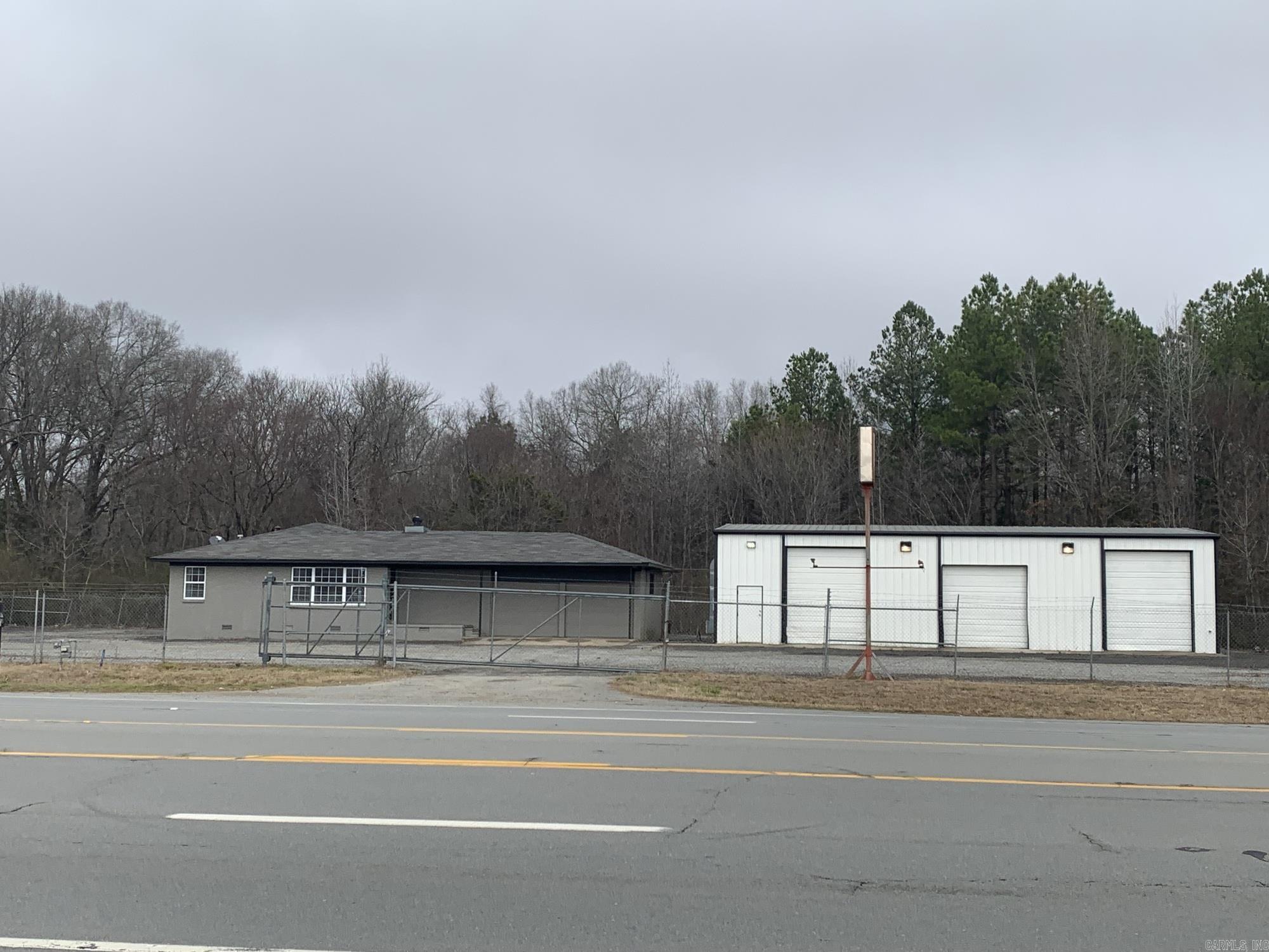 This versatile 4,372 SF commercial property offers a flexible setup with a combination of office, shop, and storage space. The office portion includes three private offices, a meeting room, reception area, and has been updated with fresh paint and new carpet. A two-door storage facility is connected to the office, providing convenient access and added utility. The metal shop features three oversized overhead doors, a restroom, and ample space for operational needs. The entire lot is fully fenced and graveled, ideal for equipment, vehicle storage, or outdoor work. The property is well-suited for contractors, service providers, light industrial users, or small business operations. High-visibility location with easy access off Highway 64 Office includes three private offices, a meeting room, and entry area Recently updated with new carpet and fresh paint Attached two-door storage facility for additional space Shop features a restroom and three large overhead doors Fully fenced lot with complete gravel coverage