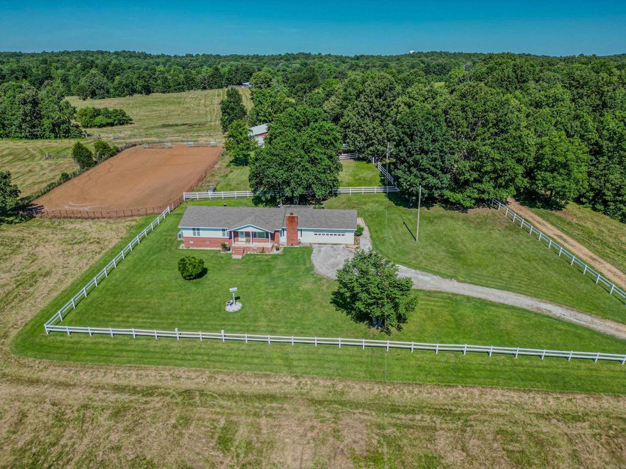 Nestled in the heart of serene countryside, this 123-acre cattle and horse ranch is a paradise for Yellowstone enthusiasts. The charming 3-bedroom, 2-bath home offers breathtaking views, perched perfectly to overlook a picturesque pond and gentle rolling hills. Equestrian lovers will delight in the 7-stall horse barn, complete with a tack room and horse wash. The property boasts a well-maintained arena, approximately 90x140 feet, and a 40' round pen, ideal for training and exercise. A 50x50 pole barn provides ample space for equipment, cattle, or extra horse stalls, featuring a pond-fed watering trough to keep your livestock refreshed. Additionally, the property includes a concrete building, once the original homestead, complete with a bathroom, adding a touch of history and charm. This ranch is more than just a property; it's a lifestyle, offering tranquility and a deep connection to nature.