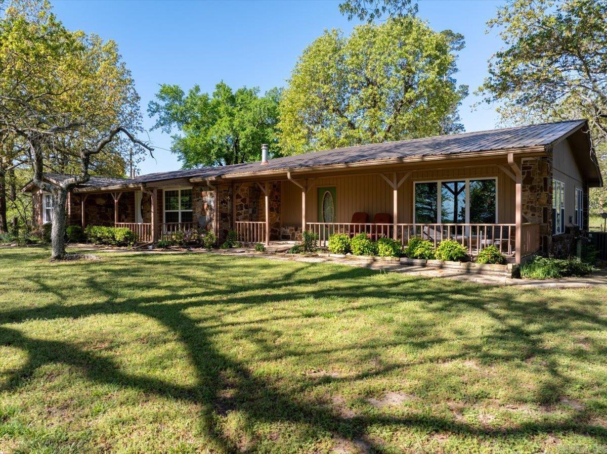 Situated just minutes from town, this incredible property truly has it all! The home has 4 bedrooms, and 3 bathrooms making it spacious and functional for those seeking larger living quarters. The kitchen has attractive hardwood cabinetry and overlooks the living room where you can entertain as your family or friends cozy up by the attractive electric fireplace. Large windows throughout the living space allow for ample natural light, and there is extensive built in storage too! Other features include an infrared SAUNA, electric toilets in each bathroom, high countertops for added accessibility, a lovely back deck and a wood fireplace in one bedroom! Step outside and you are greeted with an expansive 5 acre stocked LAKE, beautiful established landscaping and trees, and even a second smaller stocked pond! Multiple out buildings including a spacious lofted guest house, a large shop, and an even a separate woodworking shop! There is also a lovely greenhouse complete with planting tables, AND a tiny house! With easy access to Wolf Pen Gap ATV trail system and multiple build sites throughout the 35 acres and around the LAKE, this would be an ideal location to build rental cabins!