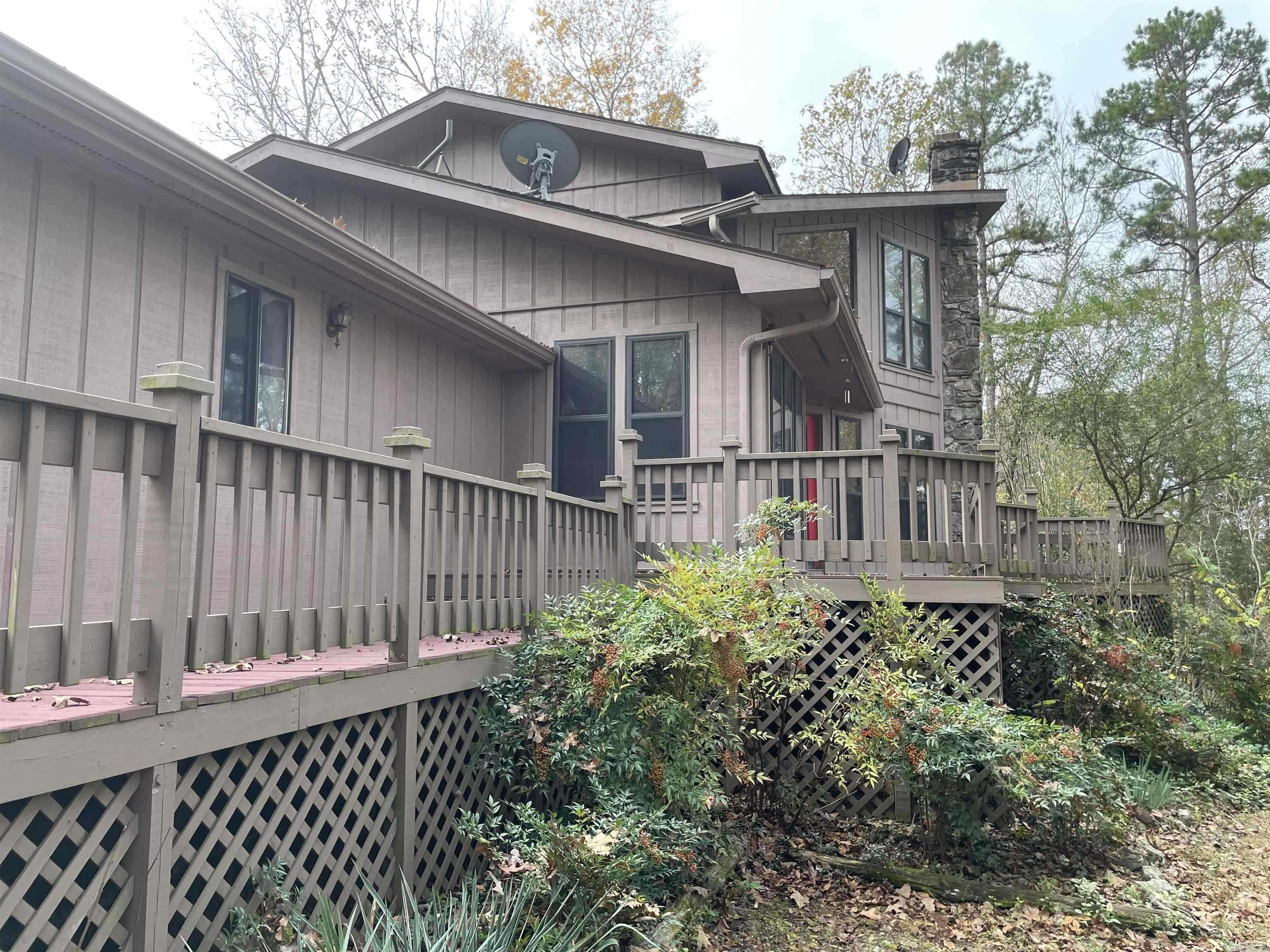 This private chalet in an amazing Lake community is located just 1.5 miles from the Old Hwy 25 Rec & boat ramp, this 3-bed, 2-bath, 2,024 SF home in Lake Forest Estates offers year-round lake views, 867 SF of wraparound decking, and a private lake access point. Features include a granite kitchen with LPG gas range, pellet stove in the living room, and updated paint/flooring. The upstairs primary suite offers serene views. Attached 2-car garage + 720 SF detached shop—ideal for lake toys, boats, or side-by-sides. A perfect setup for boating, fishing, and trail riding all year long!