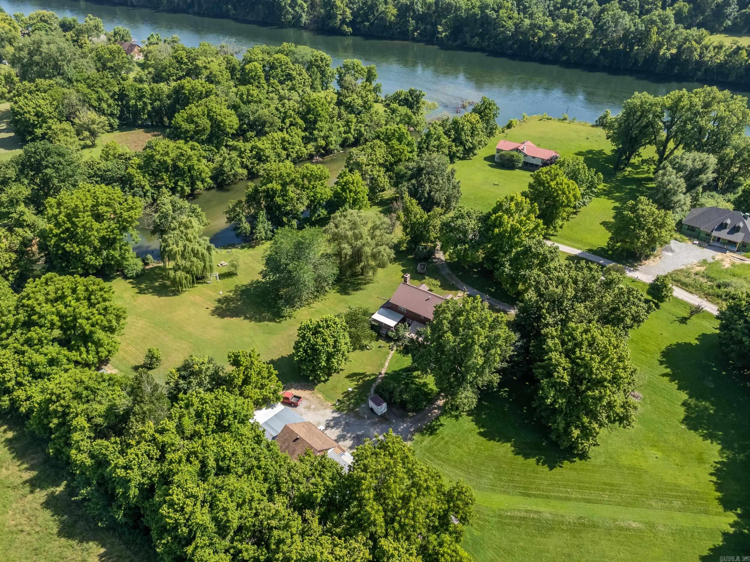 Tucked away on 5 private acres m/l, this 4-bedroom, 2-bath home is a rare find with direct access to Hightower Creek, which flows into the world-renowned White River—famous for its trout fishing. With over 2,800 sq ft of living space, this spacious home features rustic charm throughout, including a striking stone fireplace in the main living area. A wraparound covered deck invites you to unwind and soak in the peaceful setting. Outside, enjoy a private boat launch, detached garage, chicken coop, and plenty of space to garden, roam, or entertain. Whether you’re an avid angler, nature lover, or just looking for a secluded getaway, this property offers a lifestyle that’s hard to match. Located just minutes from Cotter, yet offering all the privacy of a country escape. Seller is offering a free 14 month home warranty through Home Warranty Inc. - Core Plan to buyer.