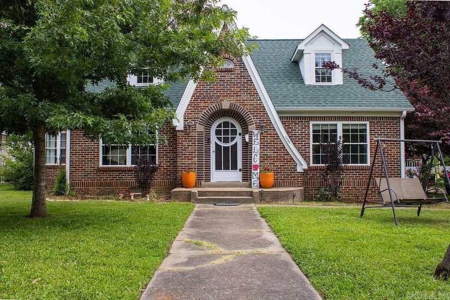 Charm, character, space, and updates come together at 1405 Hickory Ave in Mena. This beautiful Tudor Revival-style home sits on over an acre and offers over 2,000 sq. ft., 3 bedrooms, 2.5 bathrooms, a brand-new roof, updated windows, and tasteful updates throughout. Inside, you’ll find original hardwood floors, charming built-ins, unique alcoves, and a warm living room with a gas log fireplace. The bright dining room flows into an updated kitchen featuring granite countertops, stainless appliances, under-cabinet lighting, refrigerator, microwave, and new flooring. The main level includes a bedroom with built-ins and its own private bath, a half bath near the back entrance, plus an extra room that could be used as an office, hobby room, or converted into another bedroom. Upstairs are two spacious bedrooms that share a full bath. The bright laundry/sunroom overlooks the expansive backyard with a wooden privacy fence, and beyond that is another half-acre full of possibilities. Complete with a 2-car garage, concrete parking, and patio area, this classic Mena home is full of charm and room to enjoy.