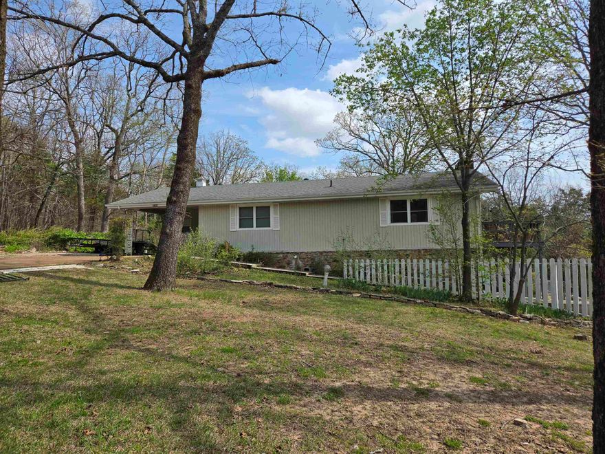 Seasonal Lakeview of Crown Lake from Primary bedroom and deck. Large kitchen/dining area with lots of cabinets and Island. Gas range, microwave fridge and dishwasher included in the list price. Huge living room (enough for office area or dining area) has sliding doors out to wrap around deck and fireplace. 2 bedrooms and 2 bathrooms on main level, plus laundry hookups. Tile flooring in kitchens and baths and carpet in the remainder. Lower level has plenty of possibilities with family room, 3rd bathroom with walkin shower, and another bedroom/office area. Sliding doors out to the patio and fenced in area. Access the shop area from the outside or from the bedroom. Includes two lots with shed, carport with extra driveway parking. Septic lines updated, HVAC less than 5 years old as well as some updated appliances. NAEC electric service means fiber optic internet from NEXT is available. If your looking for large space and a great view, then take a look at this home before it is gone!