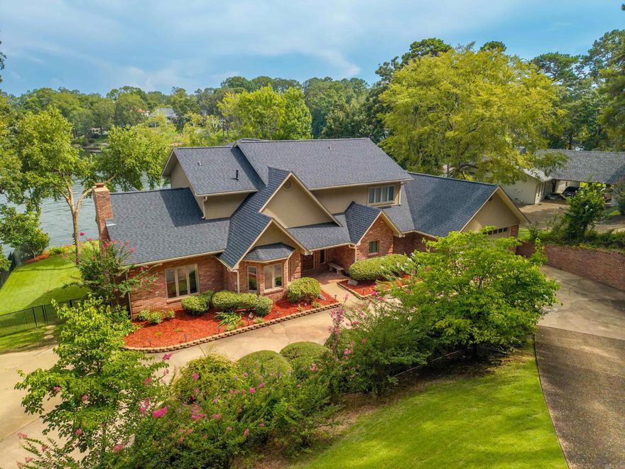 Breathtaking Lakefront Living in Lakeside School District! Welcome to 118 Legend Circle — a fully furnished, move-in-ready retreat nestled on 149 feet of pristine Lake Hamilton shoreline. This stunning property seamlessly blends indoor comfort with outdoor luxury, boasting walls of windows that frame captivating lake views from nearly every room.  The main level is designed for effortless living and entertaining, featuring a spacious master suite, two elegant living areas, a formal dining room, a private office (currently being used as a bunk room), and soaring ceilings filled with natural light. Upstairs, you'll find a second ensuite bedroom, plus two additional guest rooms and a full bath — perfect for family or visitors.  Step outside to enjoy expansive multi-level decks, a heated pool, and an exceptional outdoor kitchen and living area with a convenient half bath — your personal oasis for lakeside gatherings. The property also includes a 2-stall covered boat dock with Seadoo lift for endless water adventures.