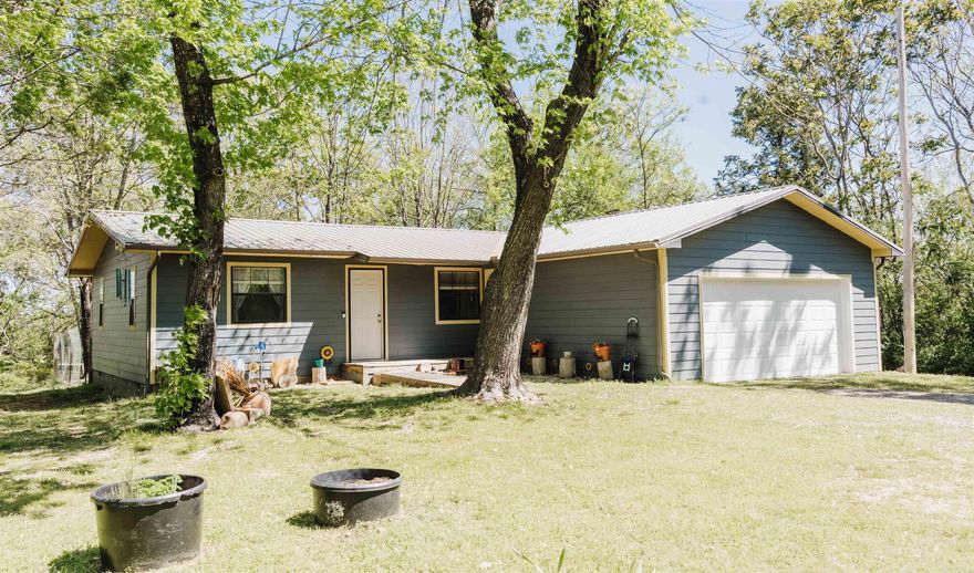 Nestled in the heart of Marshall, AR, this charming 3BD 2BA home sits on a generous 1.45-acre lot. Built in 1975, it blends timeless character with thoughtful updates. Original hardwood floors run through the main living areas and bedrooms, adding warmth throughout. The kitchen features classic oak cabinetry with plenty of storage. The primary suite includes an ensuite bathroom with a tiled shower and a relaxing whirlpool tub. Outside, enjoy a covered front porch and spacious back deck—perfect for sipping coffee or winding down in the evening. The backyard is fully fenced and includes a dog kennel, ideal for pet lovers. The large yard and surrounding woods provide a peaceful setting while still being minutes from dining and shopping. An enclosed carport has been converted into a garage, offering secure parking and extra storage. Whether you're searching for a forever home, a weekend retreat, or an investment near the beautiful Buffalo National River, this property is full of potential!