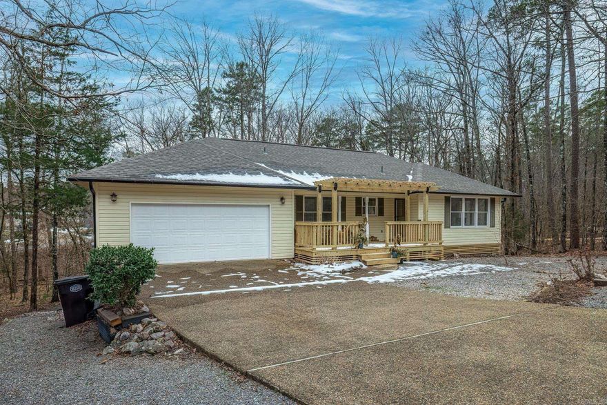 Welcome to 19 Jabali Lane, Hot Springs Village ARKANSAS. This end-of-the-road property offers wooded privacy. A newly constructed pergola covers the front deck for your leisurely enjoyment. The newly updated interior features Shaw luxury vinyl plank flooring, new lighting and ceiling fans. The open floor plan offers granite countertops, updated cabinets and hardware, stainless steel kitchen appliances and LED recessed lighting. The washer and dryer are in good condition and convey with the property. The primary bedroom boasts an en-suite bath featuring double sinks with a granite vanity, lighted mirrors and a tiled shower for that spa feeling. French doors in the primary bedroom lead to a huge newly-constructed deck off the back of the house offering a private wooded oasis in the trees. While the owners occupy the main level, guests will be welcomed by the newly carpeted lower level featuring two bedrooms and a full bath. The adjoining bath is nicely appointed with granite vanity, LED lighting and lighted mirror. The guest bath offers a full-size tub/shower and ample cabinets. Access the outdoors from the bedrooms through French doors. The property has a minimal maintenance yard.