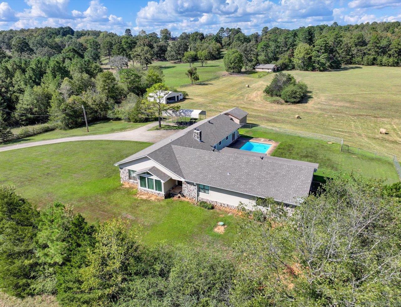 4 bedroom 3 1/2 bath well maintained home sitting on over 38 acres of gently rolling pasture land! Sit by your in-ground pool while you watch your horses, cattle and any other creature your heart desires frolic in this wide open space! This property has a 3 stall horse barn with tack room, a hay barn and several out buildings. Other features of this property include a pond, fenced back yard and a paved tree lined drive to the house. Included with purchase are the following items: tractor, riding lawnmower, an 8' trailer, an 18' trailer and a side by side. If you are searching for peace and serenity, look no further!!