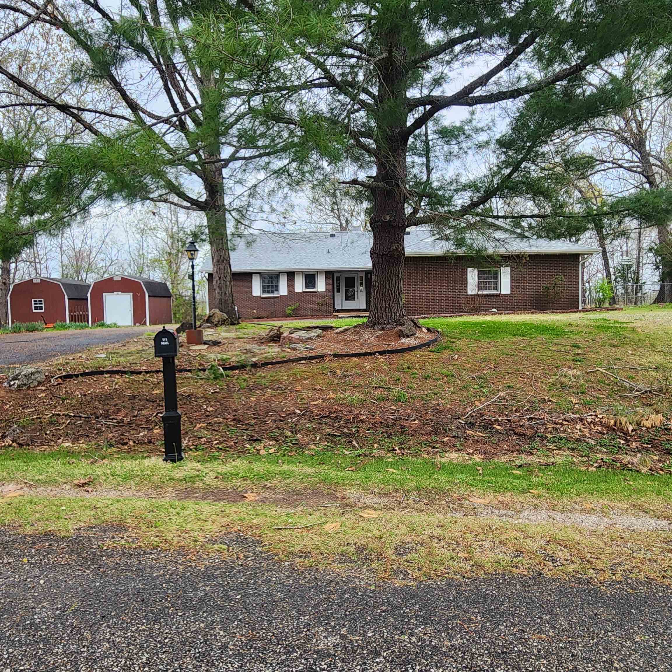 Outstanding home with seasonal lake view of Crown Lake from atop the hill in South Shore subdivision of Horseshoe Bend. This brick home has 3 bedrooms, 2 full bathrooms and a laudry with a stainless steel deep sink. A formal living room and a family-room w/ a double-sided fireplace that backs up to the sunroom. Gas Logs are new. It has a storm-shelter style basement and shop area, along with 2 outbuildings. A fenced in area for the pups. It has a Gazebo with a fireplace, a ceiling fan and beautiful cedar siding inside. It has plenty of seating area and is screened-in to. There are seasonal views of Crown lake from the back deck as well as out front when checking the mail. The roof was just replaced with architectural shingles that come with a 40-year transferable warranty for your peace of mind. This home has a termite contract already on it. The HVAC was replaced 4 years ago. The water heater is 5 yrs old and there is a water softner already installed. The 2-car garage w/ remote door opener has interior and exterior doors. The primary bedroom has an en-suite bathroom. Plenty of storage and built-ins throughout this home. Schedule your appointment to see this one soon.