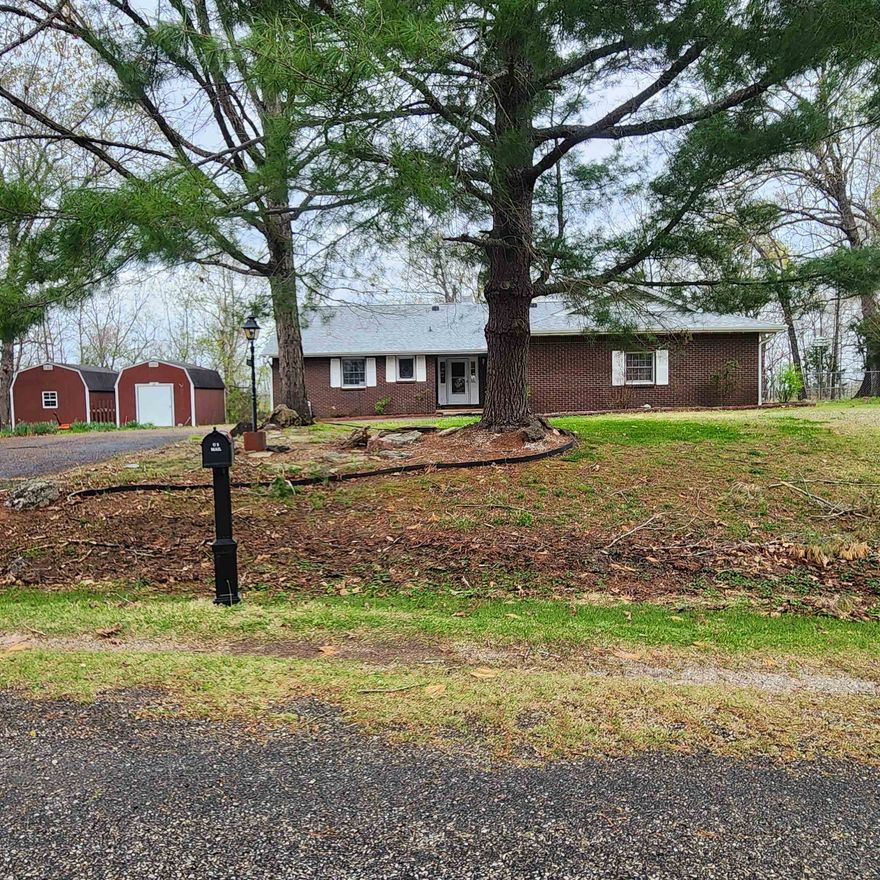 Outstanding home with seasonal lake view of Crown Lake from atop the hill in South Shore subdivision of Horseshoe Bend. This brick home has 3 bedrooms, 2 full bathrooms and a laudry with a stainless steel deep sink. A formal living room and a family-room w/ a double-sided fireplace that backs up to the sunroom. Gas Logs are new.  It has a storm-shelter style basement and shop area, along with 2 outbuildings. A fenced in area for the pups. It has a Gazebo with a fireplace, a ceiling fan and beautiful cedar siding inside. It has plenty of seating area and is screened-in to. There are seasonal views of Crown lake from the back deck as well as out front when checking the mail. The roof was just replaced with architectural shingles that come with a 40-year transferable warranty for your peace of mind. This home has a termite contract already on it. The HVAC was replaced 4 years ago. The water heater is 5 yrs old and there is a water softner already installed. The 2-car garage w/ remote door opener has interior and exterior doors. The primary bedroom has an en-suite bathroom. Plenty of storage and built-ins throughout this home. Schedule your appointment to see this one soon.