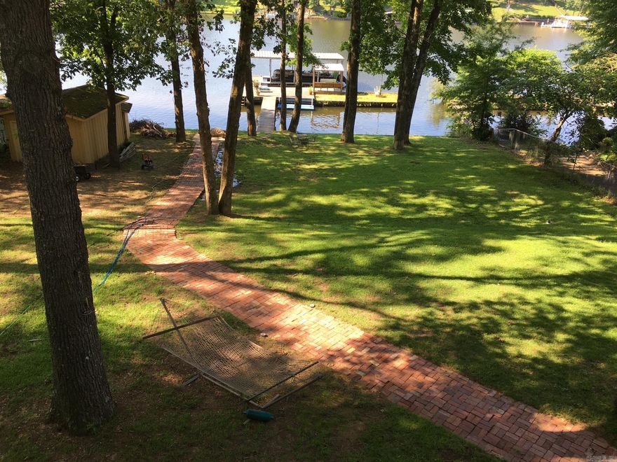 Wonderful lake home close to everything! Tons of updates including new windows, new roof, 2 kitchen areas, covered porch. New island in upstairs kitchen, deck replaced, some original hardwoods along with some new flooring. Fresh exterior paint. 2 HVAC units, one new and one heat is new. Roof 2 years old! Primary and 2 other bedrooms main level, 1 bedroom and bath downstairs. Downstairs bath has steam shower and huge bedroom. Gorgeous views, covered boat dock, covered deck! Many more pictures coming.